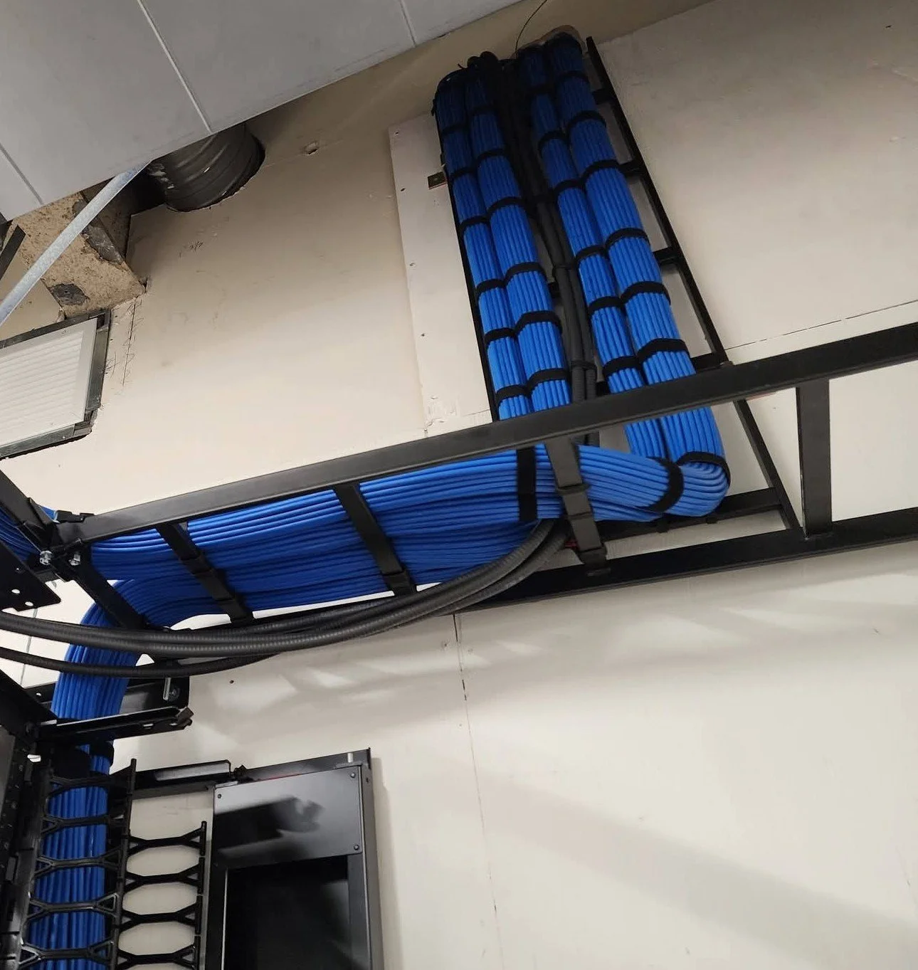 Professionally dressed blue Cat 6 structured cabling routed along a ladder rack in a commercial IDF data room, installed by the low-voltage experts at Koncept Electric in Southern Nevada.