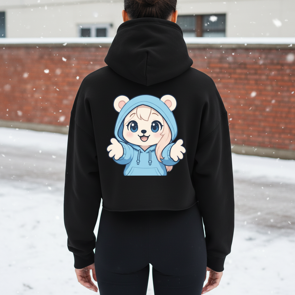 Person wearing a black hoodie with a cartoon character of a cute bear in a blue hoodie on the back, standing outdoors in winter with snow falling.