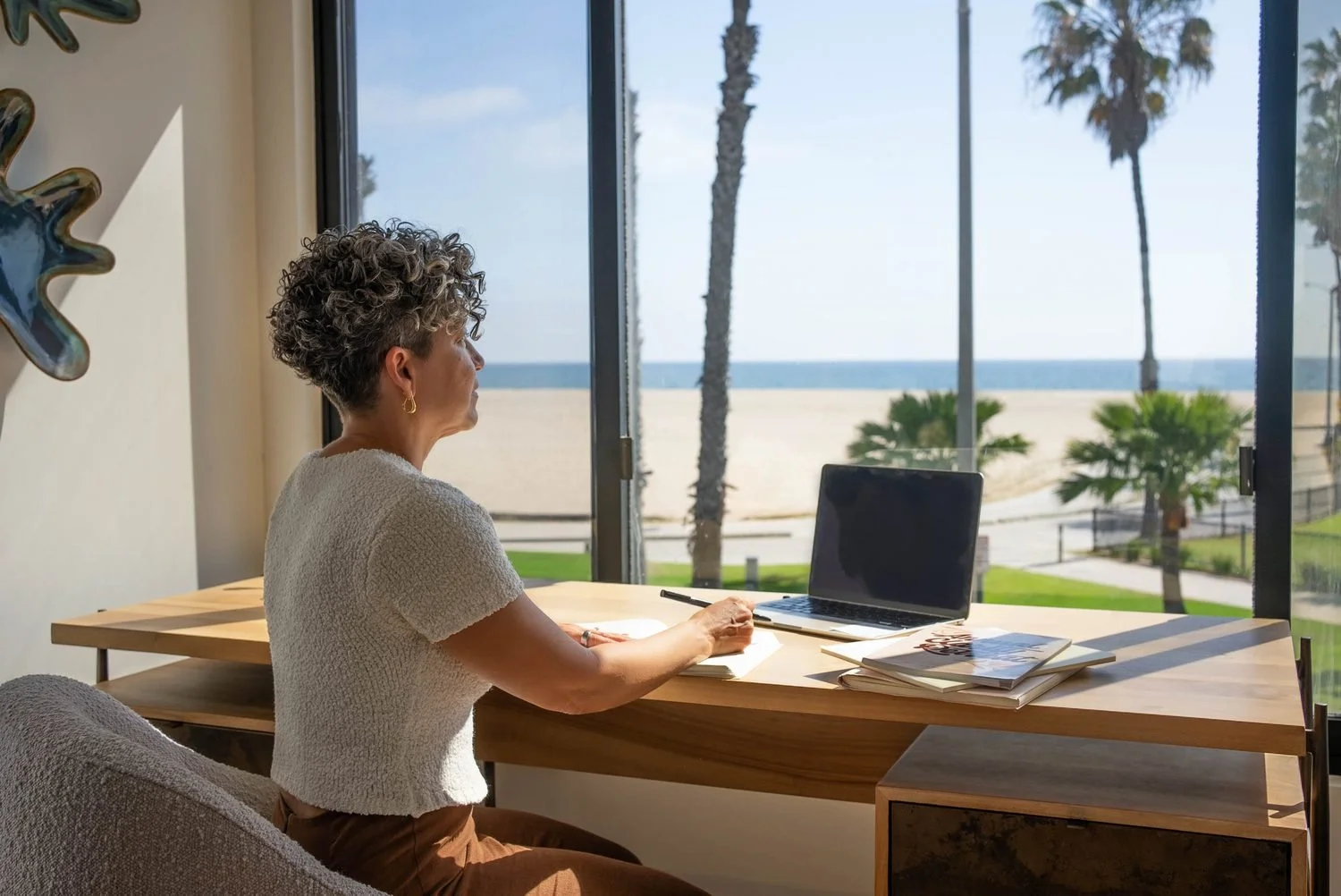 Kerry Ann working at a desk overlooking the ocean