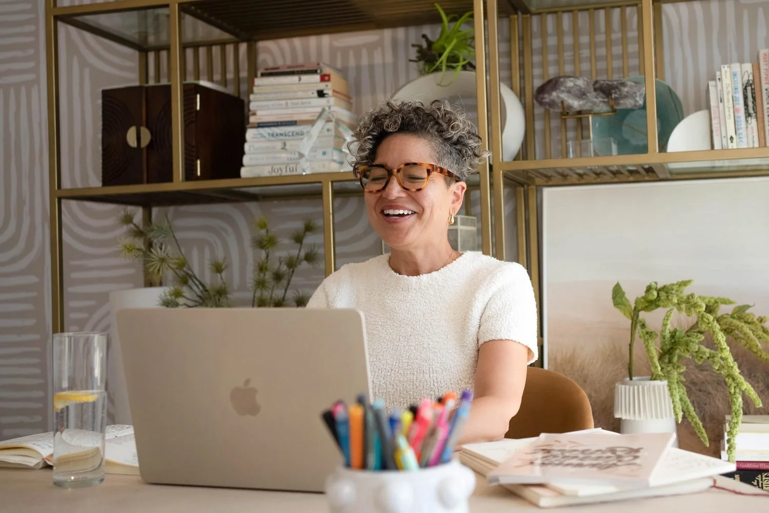 Midlife coach for women, Kerry Ann Rockquemore working at her desk on a laptop