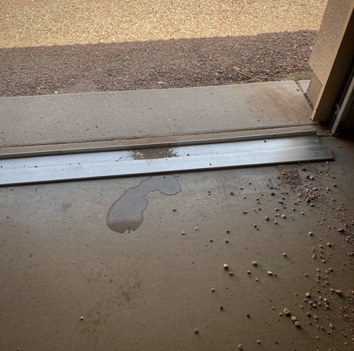 drywall crack near garage door threshold with UV lamp