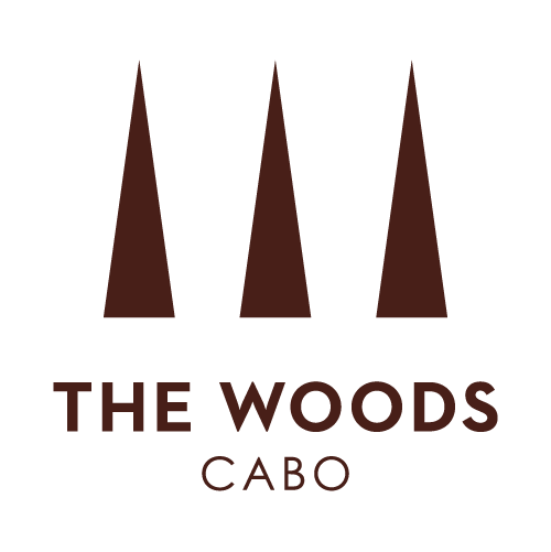 Logo with three stylized trees above the text 'The Woods Cabo'.