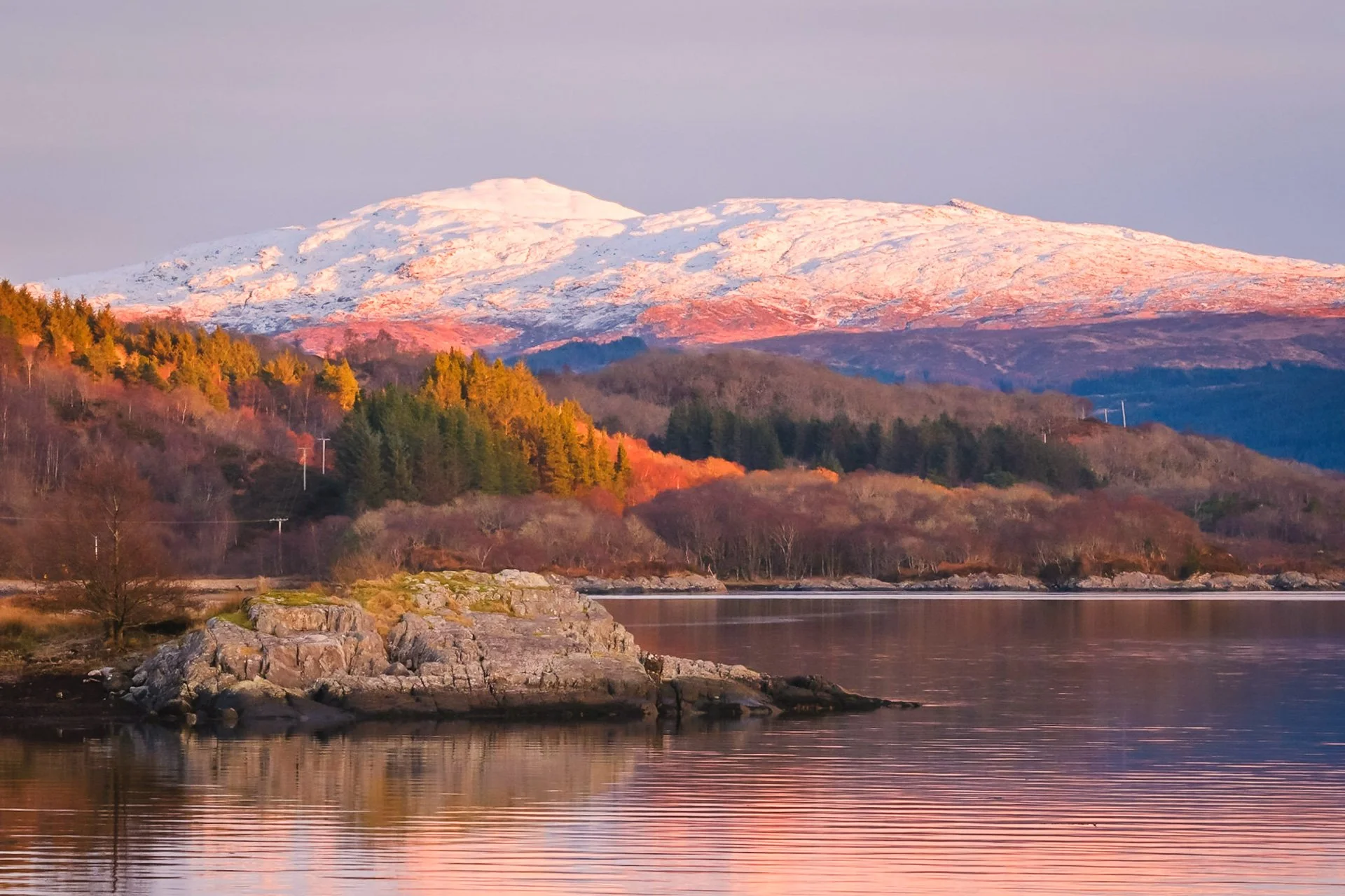 Warm light of sunset on a snow-covered mountain, Fuar Bheinn in Ardgour, with Loch Sunart in the foreground | Sunart, Scotland | Steven Marshall Photography