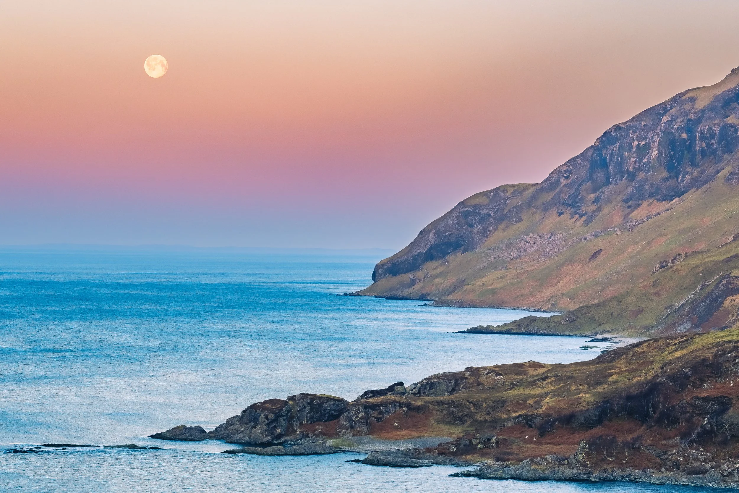 A full moon setting out beyond Maclean’s Nose against a colourful sunrise sky | Ardnamurchan Scotland | Steven Marshall Photography