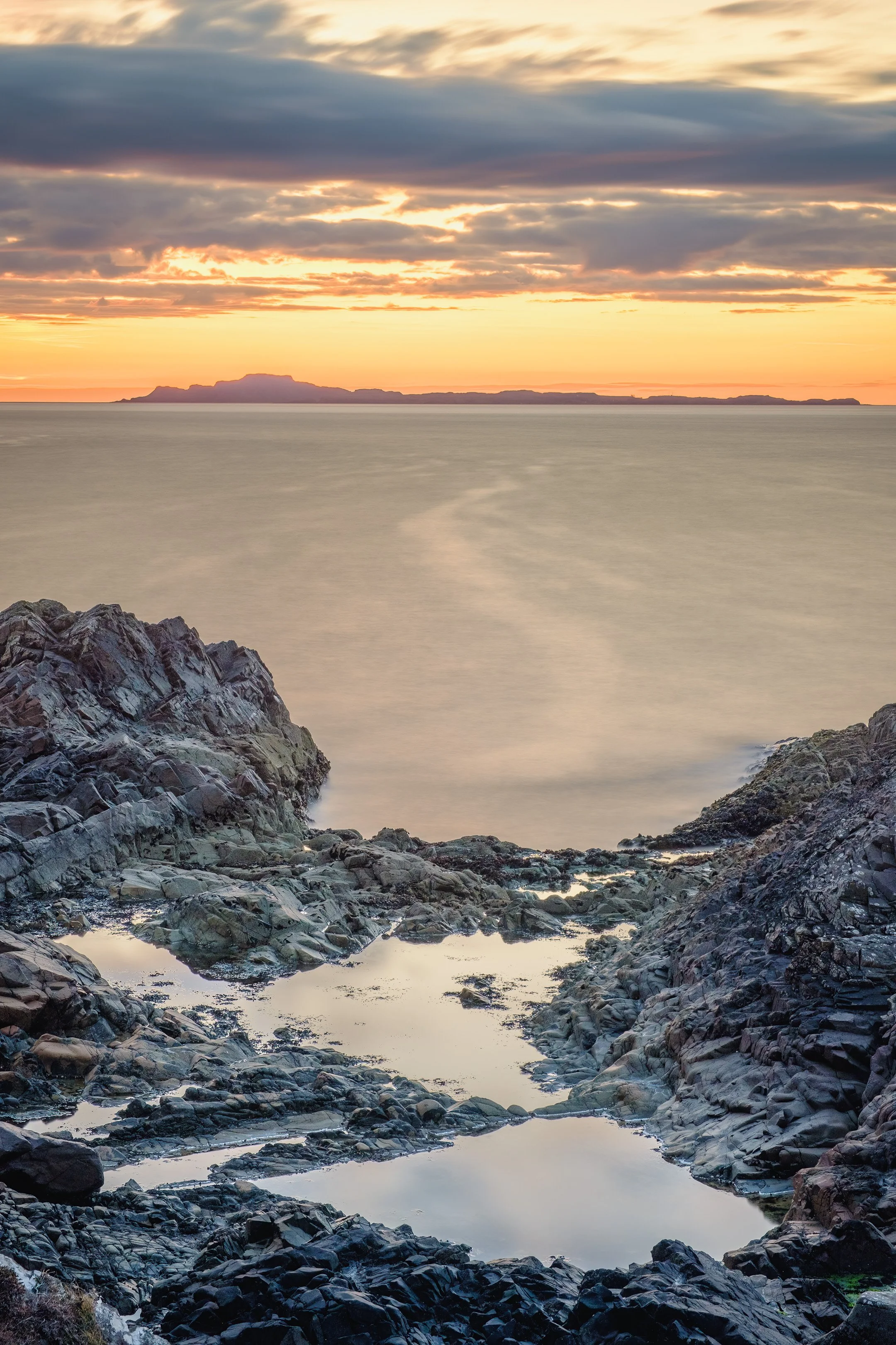 The Small Isle of Muck beneath an orange sunset sky at Fascadale | Ardnamurchan Scotland | Steven Marshall Photography