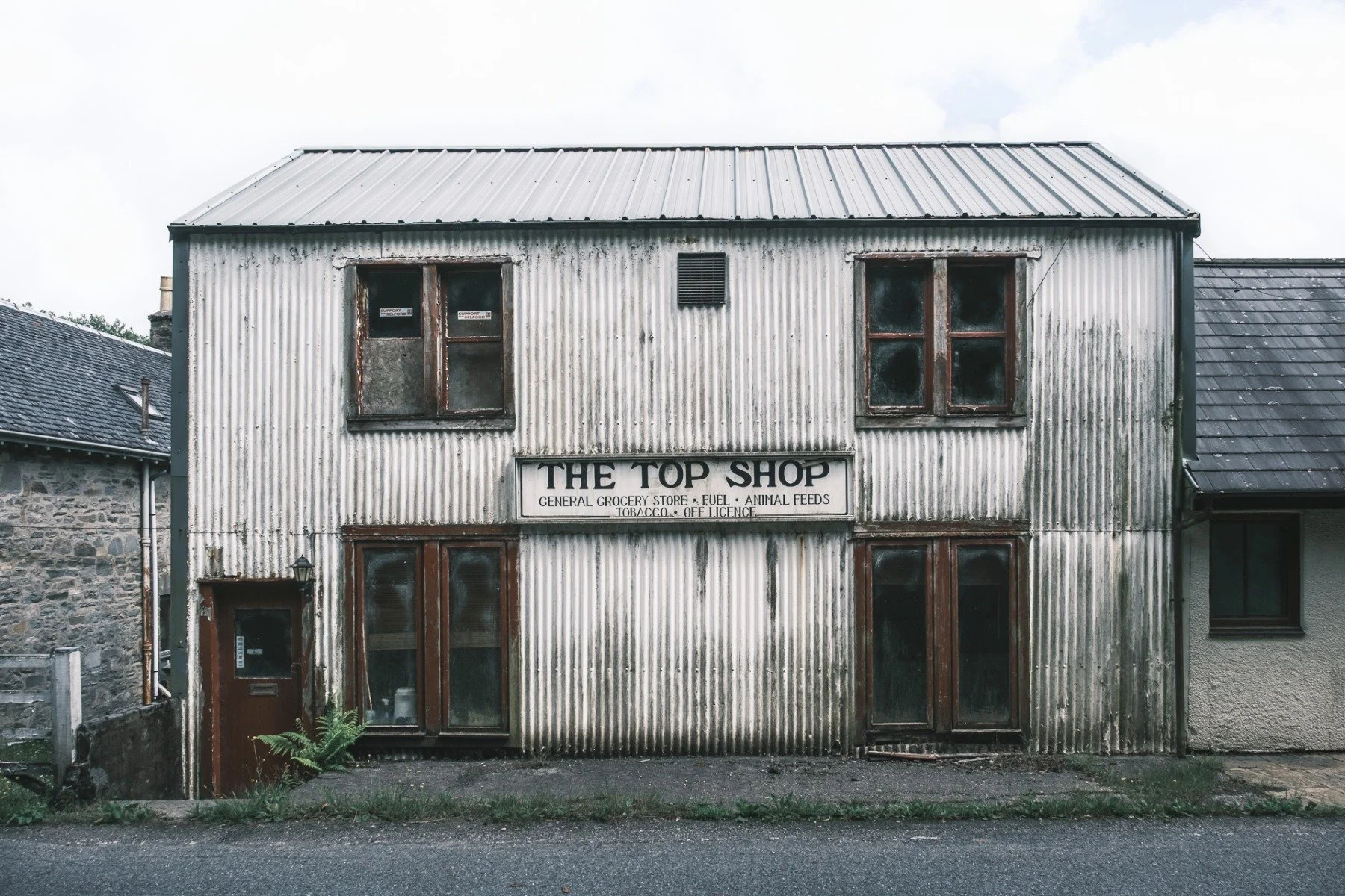 A white painted, corrugated tin/iron building called the Top Shop with a rusting roof | Acharacle Ardnamurchan Scotland | Steven Marshall Photography