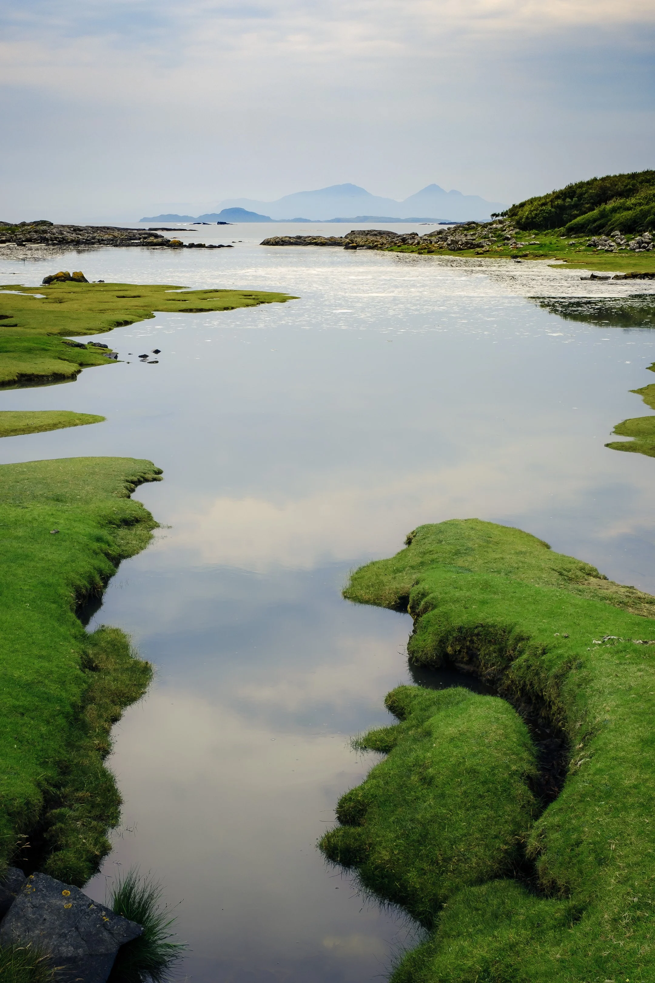 A calm sea during a high tide at Portuairk with the Small Isles on the horizon | Ardnamurchan Scotland | Steven Marshall Photography
