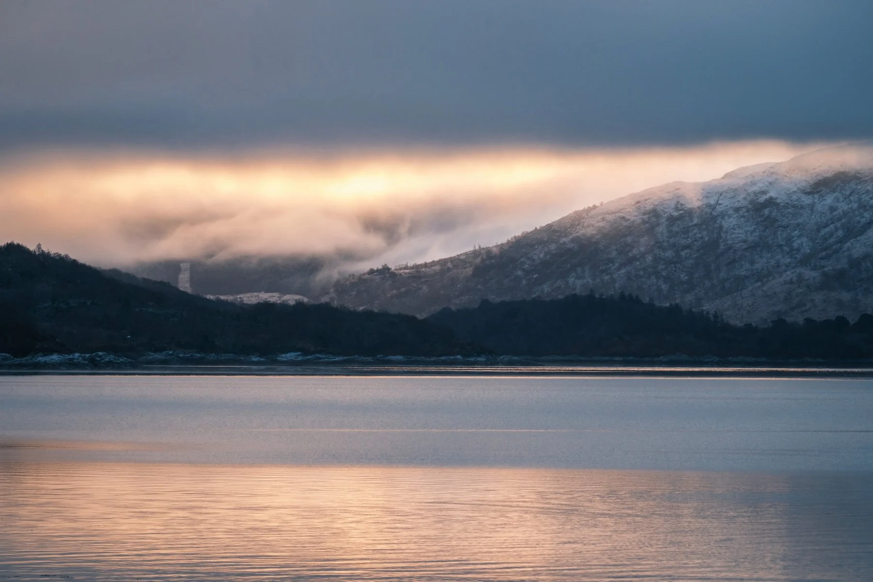 Golden winter morning light breaks through thick low cloud above the snow-covered hills of Morvern. Taken at Resipole. | Sunart Scotland | Steven Marshall Photography