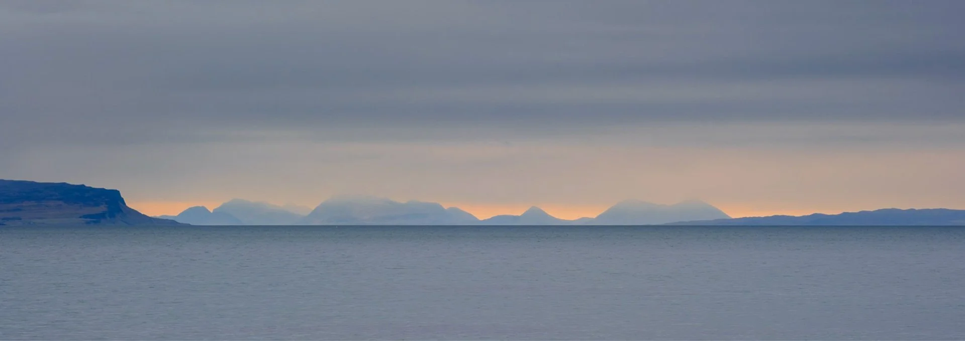 The Skye Cuillin viewed from Fascadale and silhouetted against an orange and blue sky | Ardnamurchan, Scotland | Steven Marshall Photography