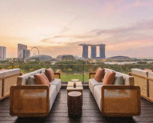 Sunset view through a window showing the Marina Bay Sands hotel and the Singapore Flyer Ferris wheel in Singapore.
