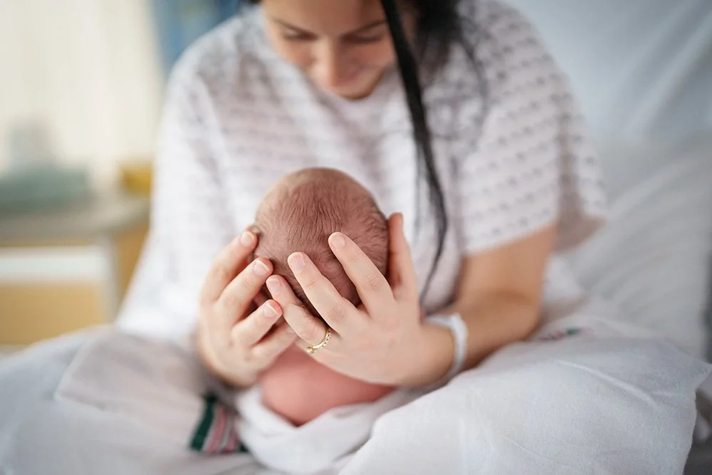 Close-up of a new mother cradling her infant, reflecting delicate postnatal emotional care