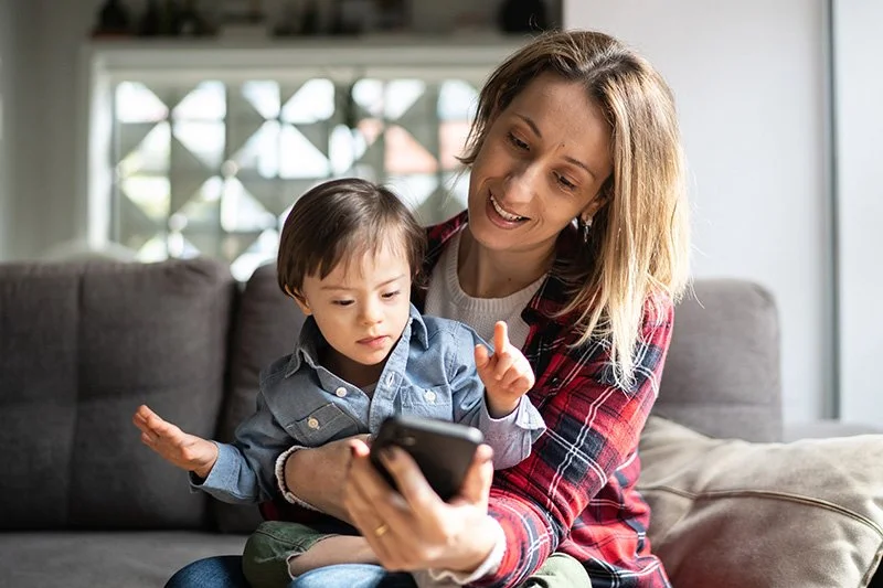 Mother and young boy sharing a happy moment together on a couch, illustrating psychological support for matrescence and identity transition