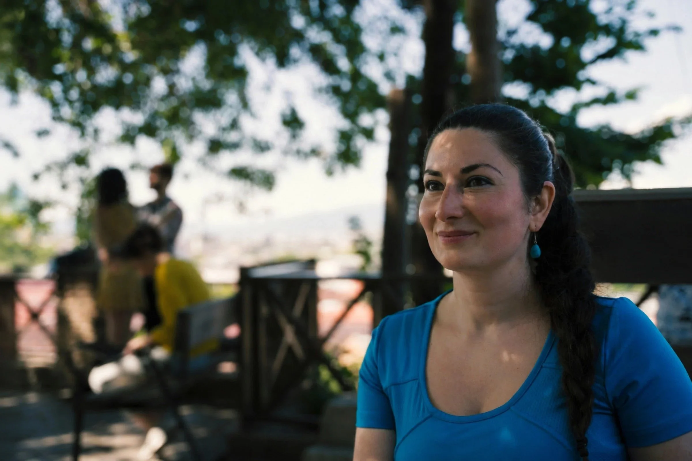 A woman smiling under a tree.