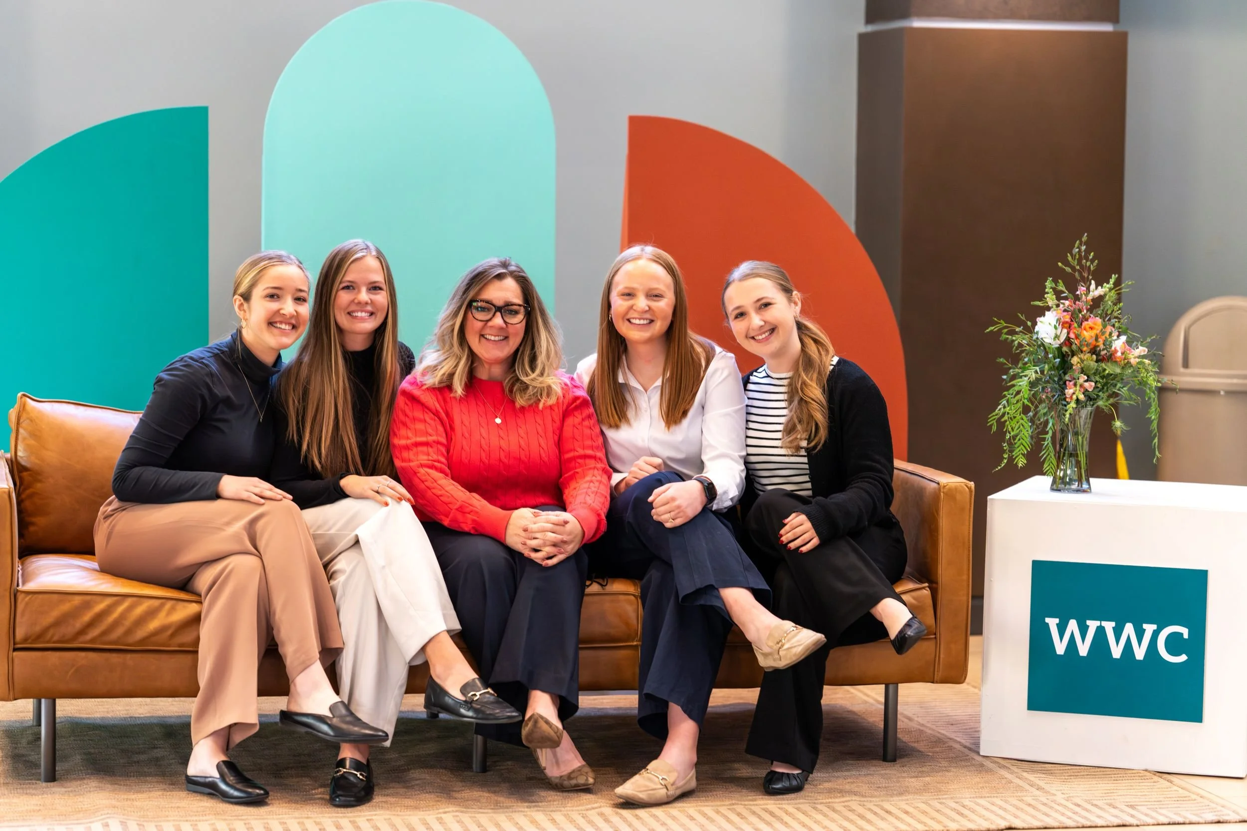 Women sitting on a couch and smiling at a Women Work and Calling event.