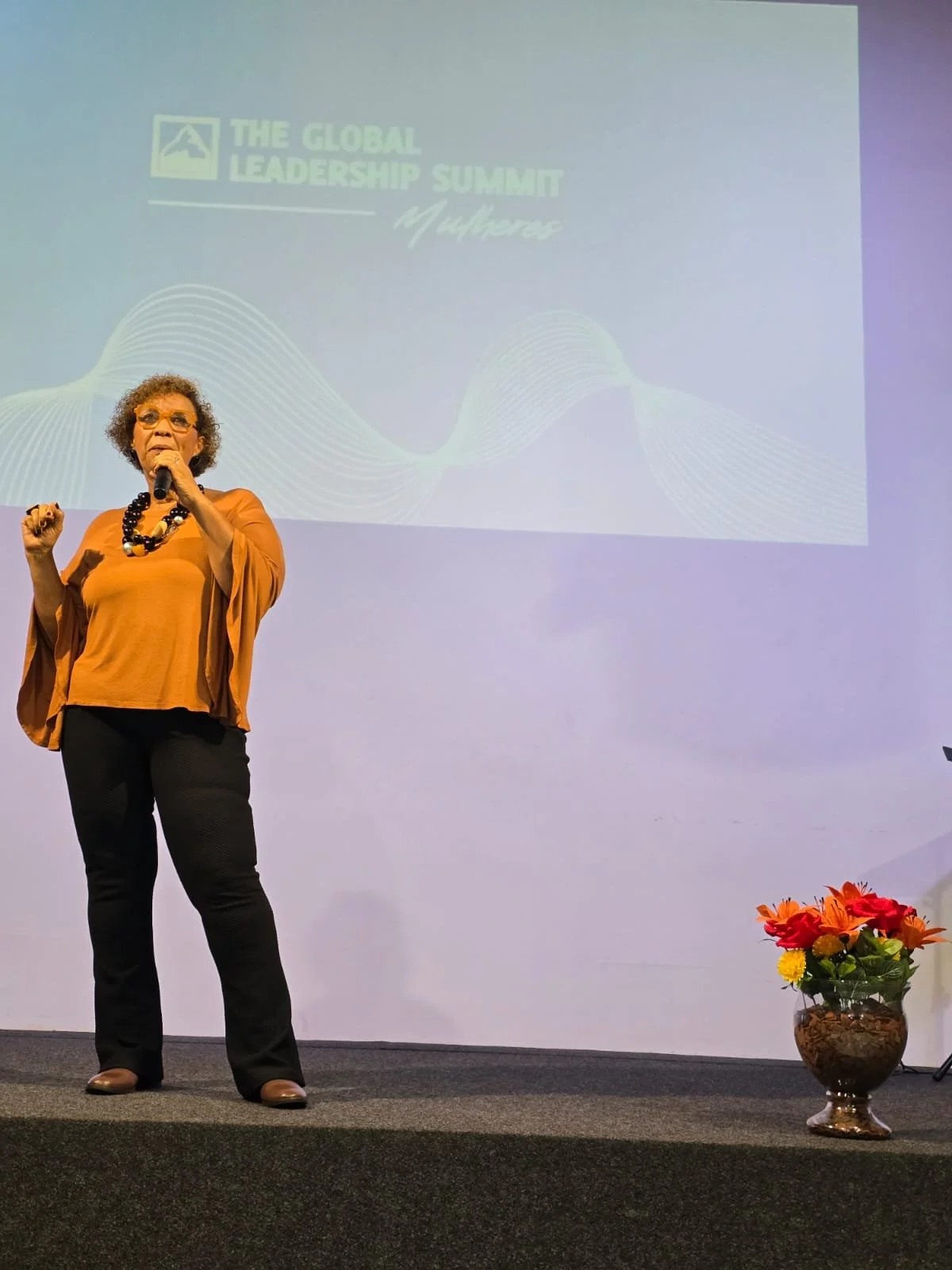 Carmen Soares, a leader from Brazil speaking from stage at a women's leadership conference