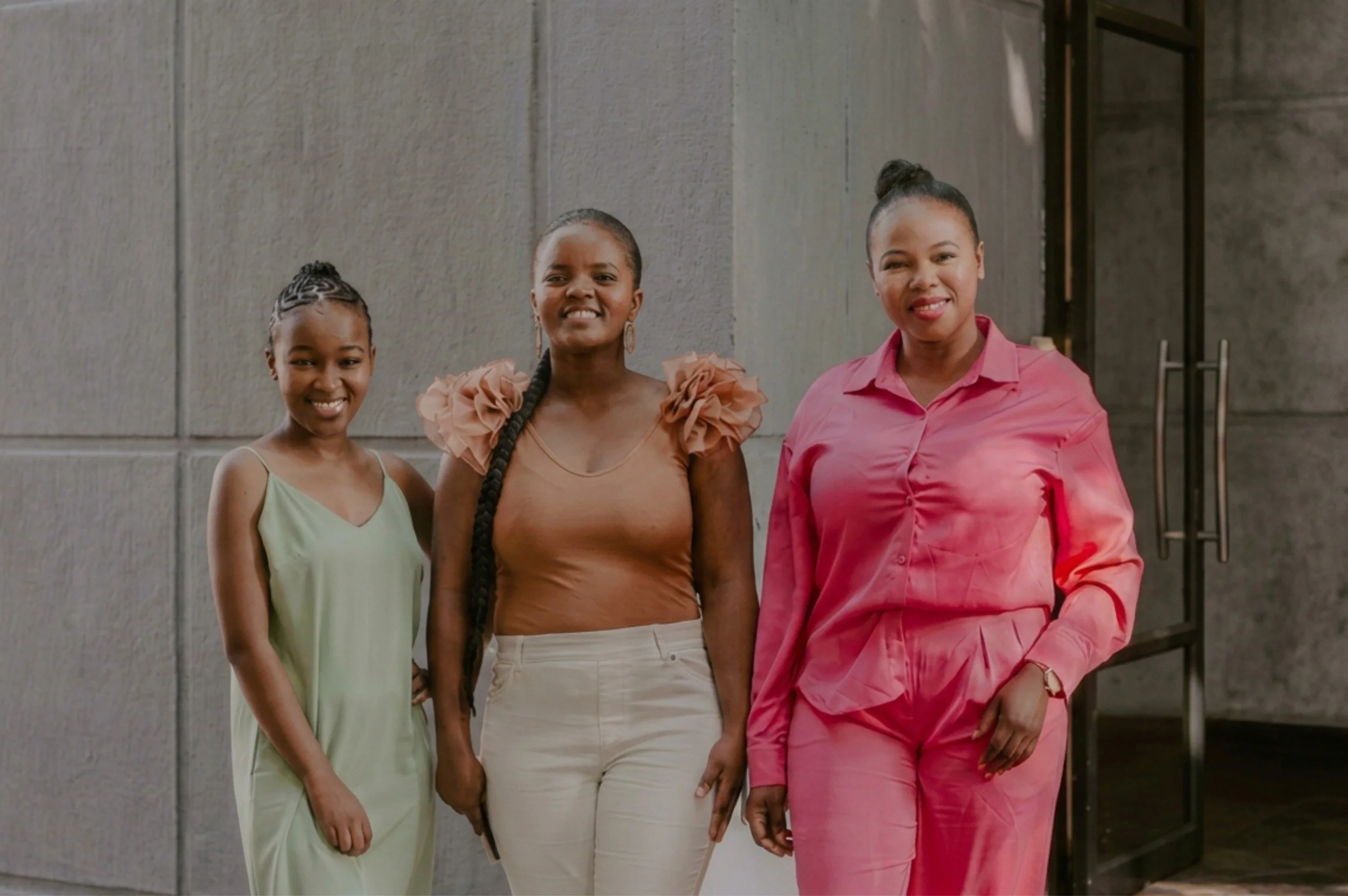 Women from South Africa smiling and standing shoulder to shoulder.