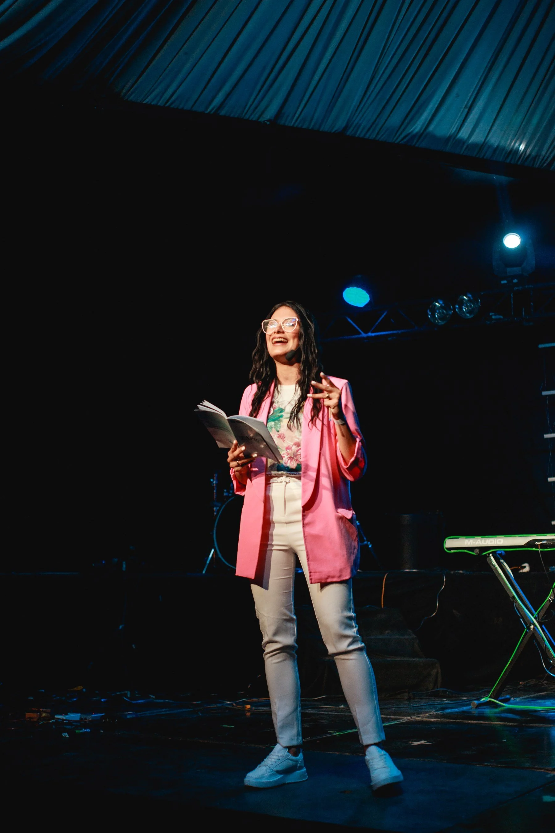 A woman speaking from stage, teaching leadership skills to women in leadership.