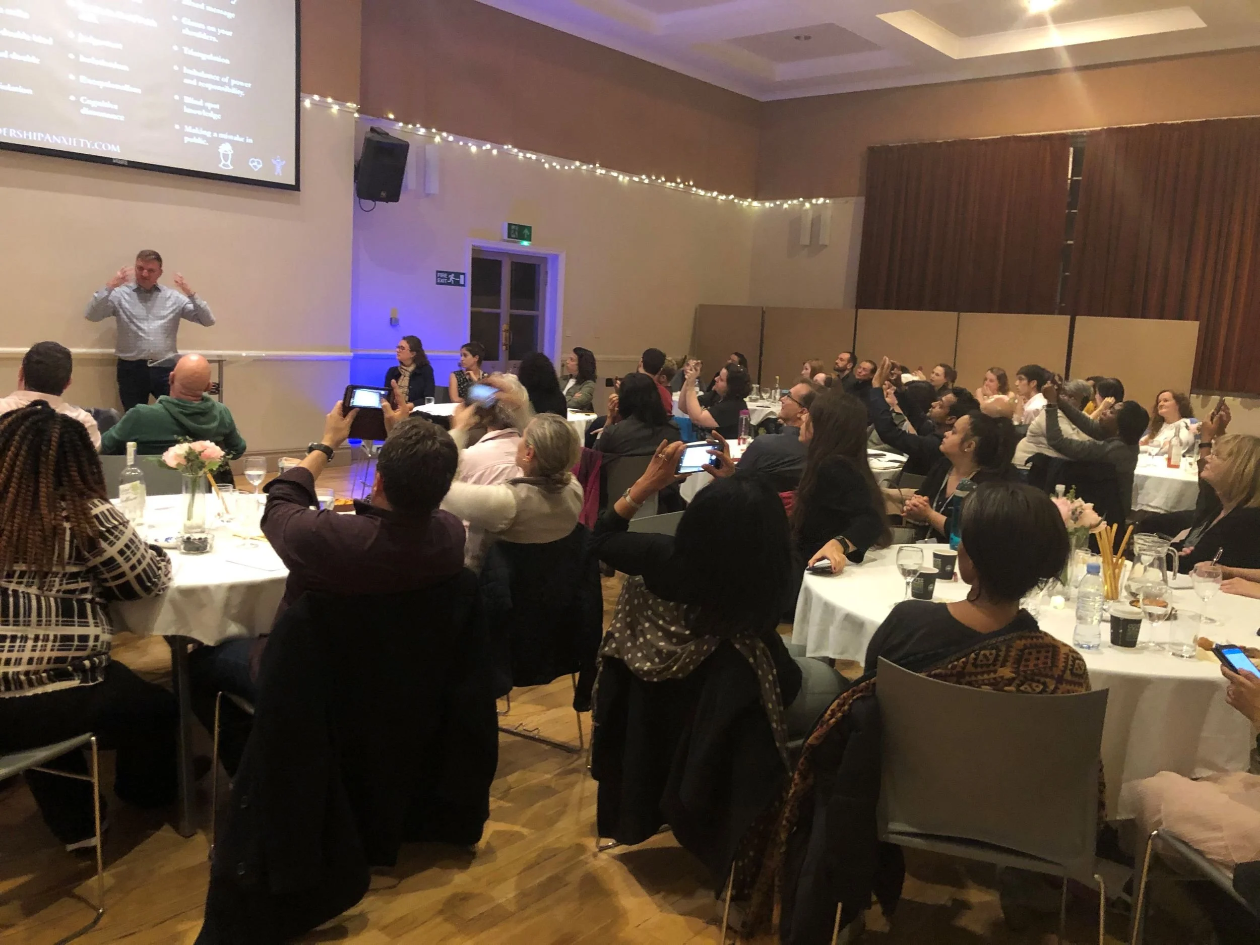 Steve Cuss speaking on leadership and faith to a crowd of global leaders at an event.