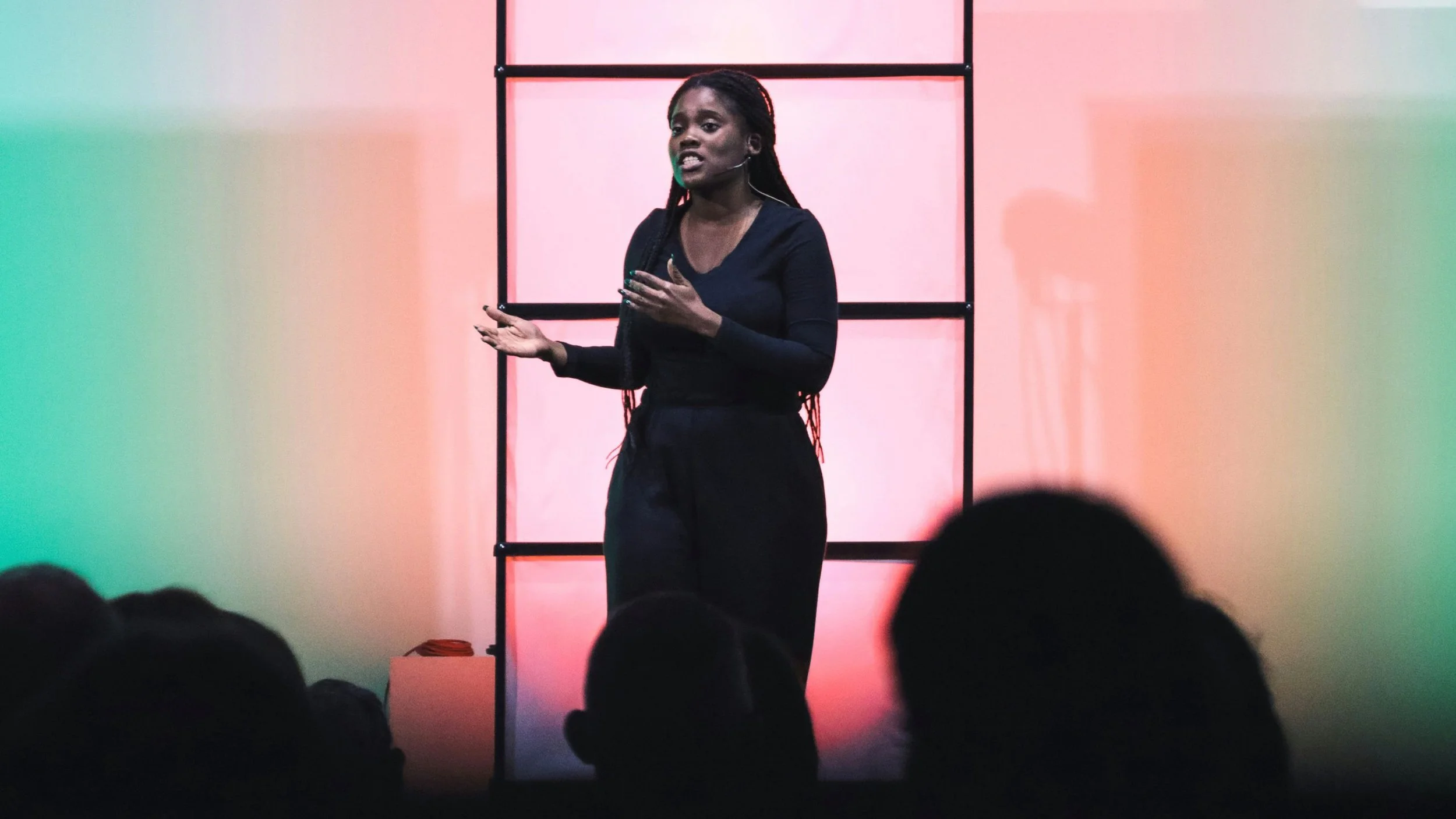 A woman leader speaking from stage at a Kyria Network event.