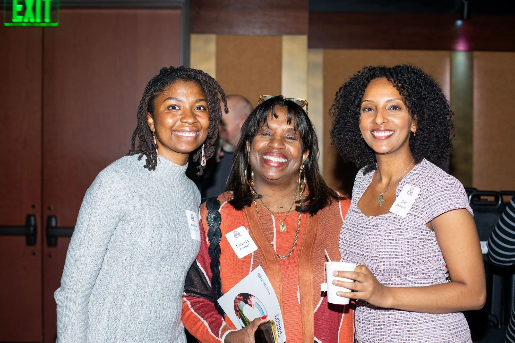 Women leaders smiling at an event where they are learning new leadersip skills.