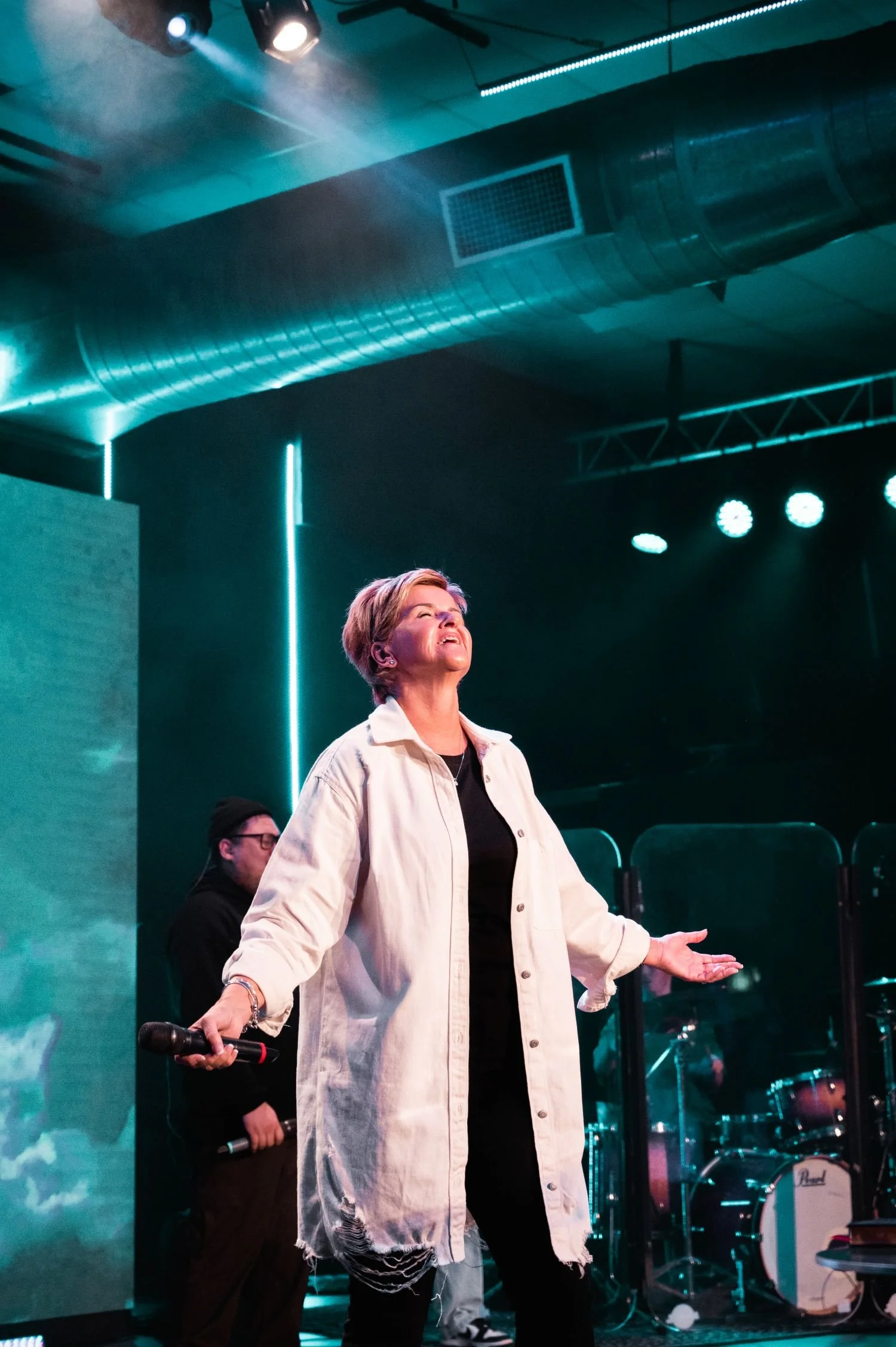 Jenny Gilpin praying on stage at an Esther's Table women in leadership event.