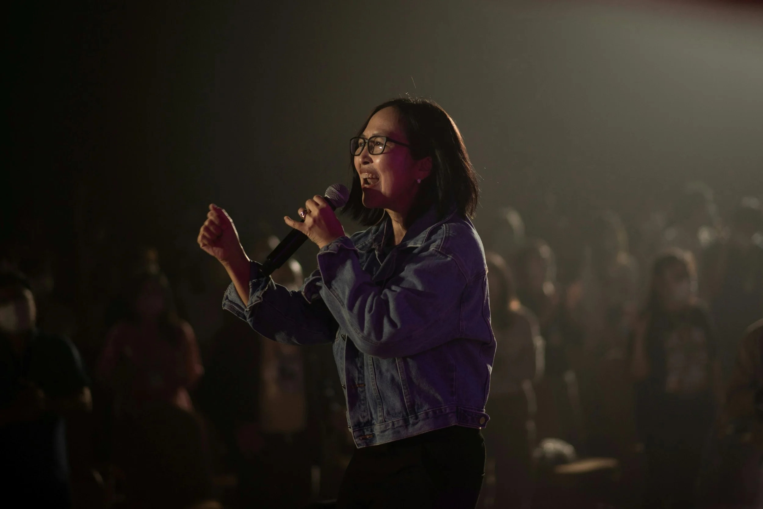 A woman leader speaking confidently from stage