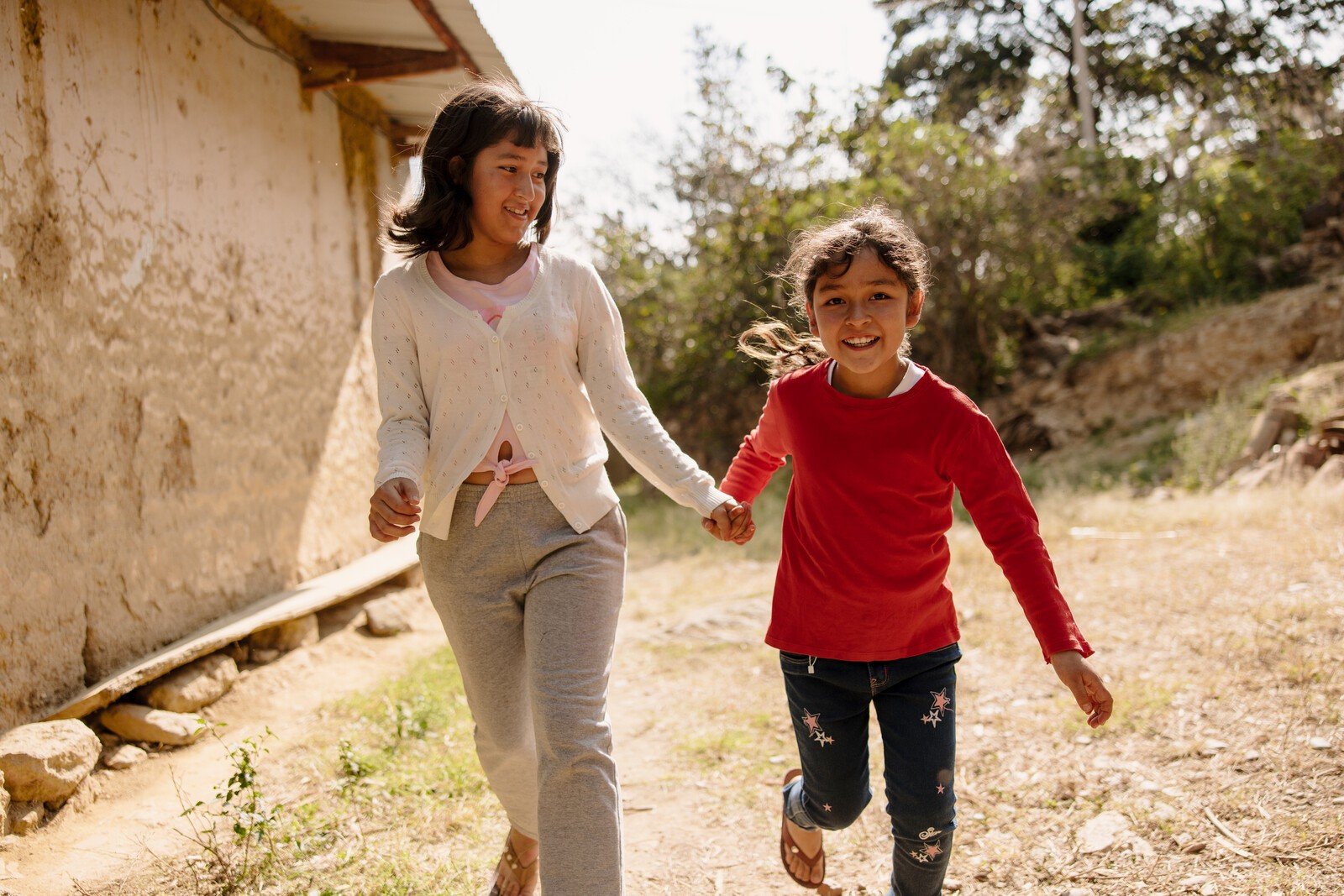 Young women smiling, laughing and running in the sunshine.