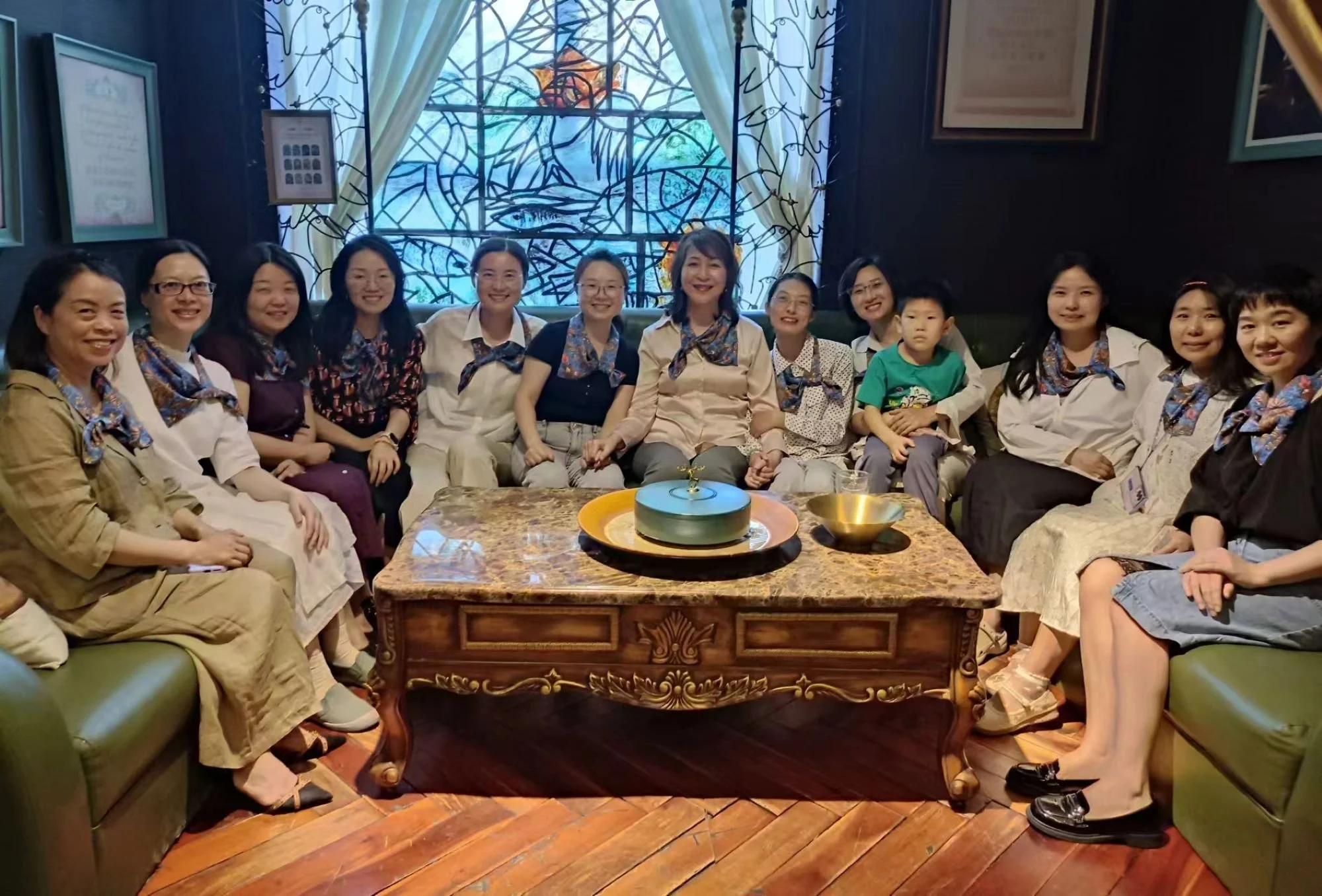 Women in a teahouse, sitting and smiling as they talk about faith and leadership.