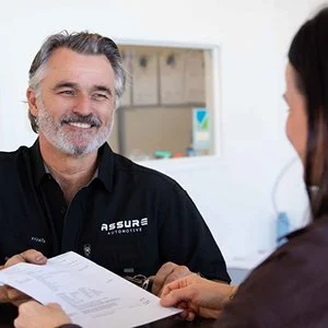Assure-Automotive-Robina-owner-smiling-with-client