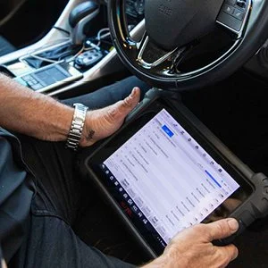 Assure-Automotive-Robina-mechanic-checking-car-details-on-tablet