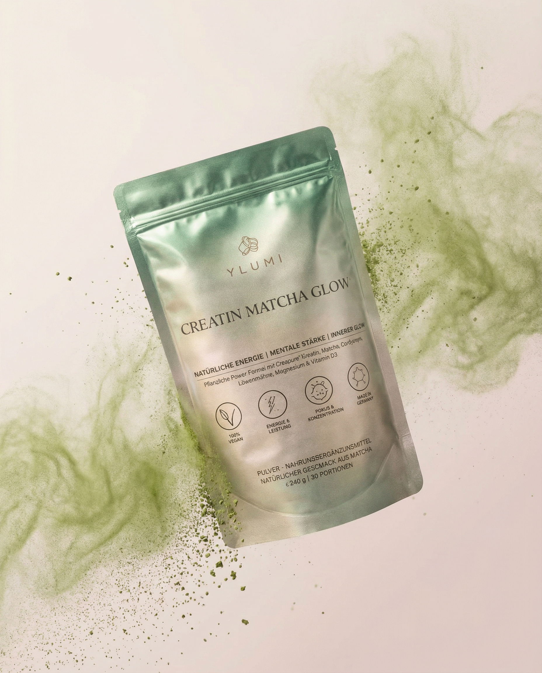 A silver packet of Ylumi Matcha Glow with scattered green matcha powder around it on a white surface.