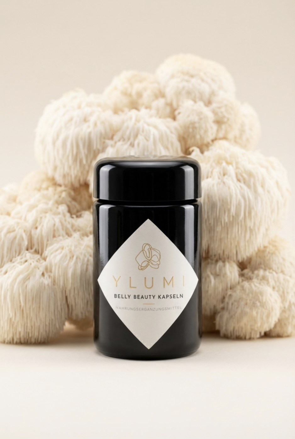 Black container labeled 'Y LUMI Belly Beauty Kapseln' in front of beige textured objects