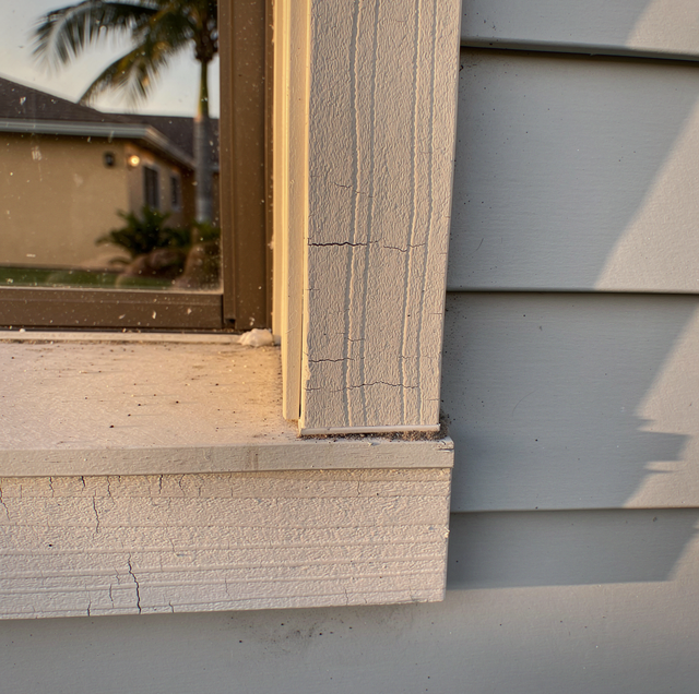 weathered exterior trim boards with peeling paint on house