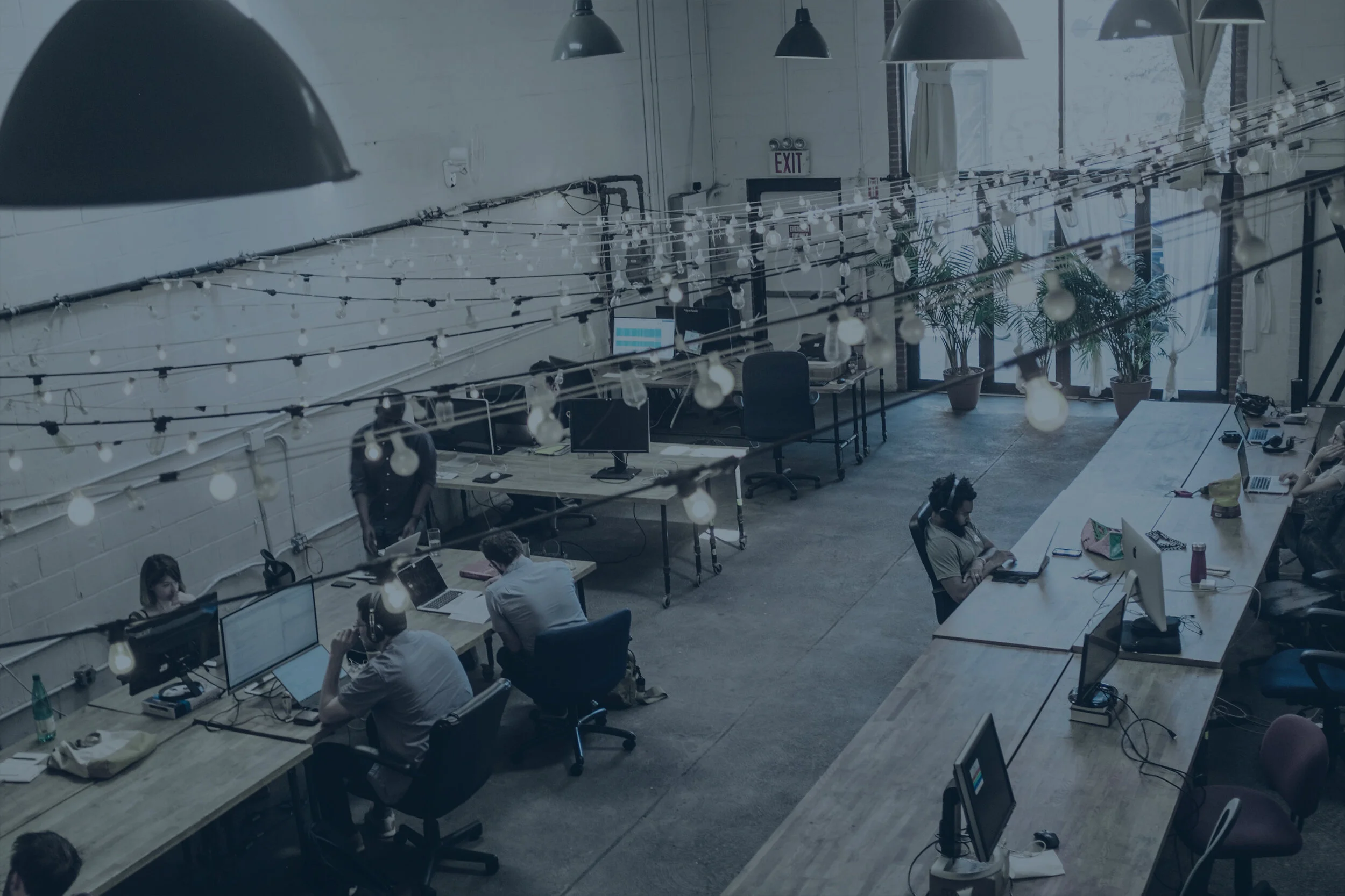 A busy coworking space with long, wooden tables