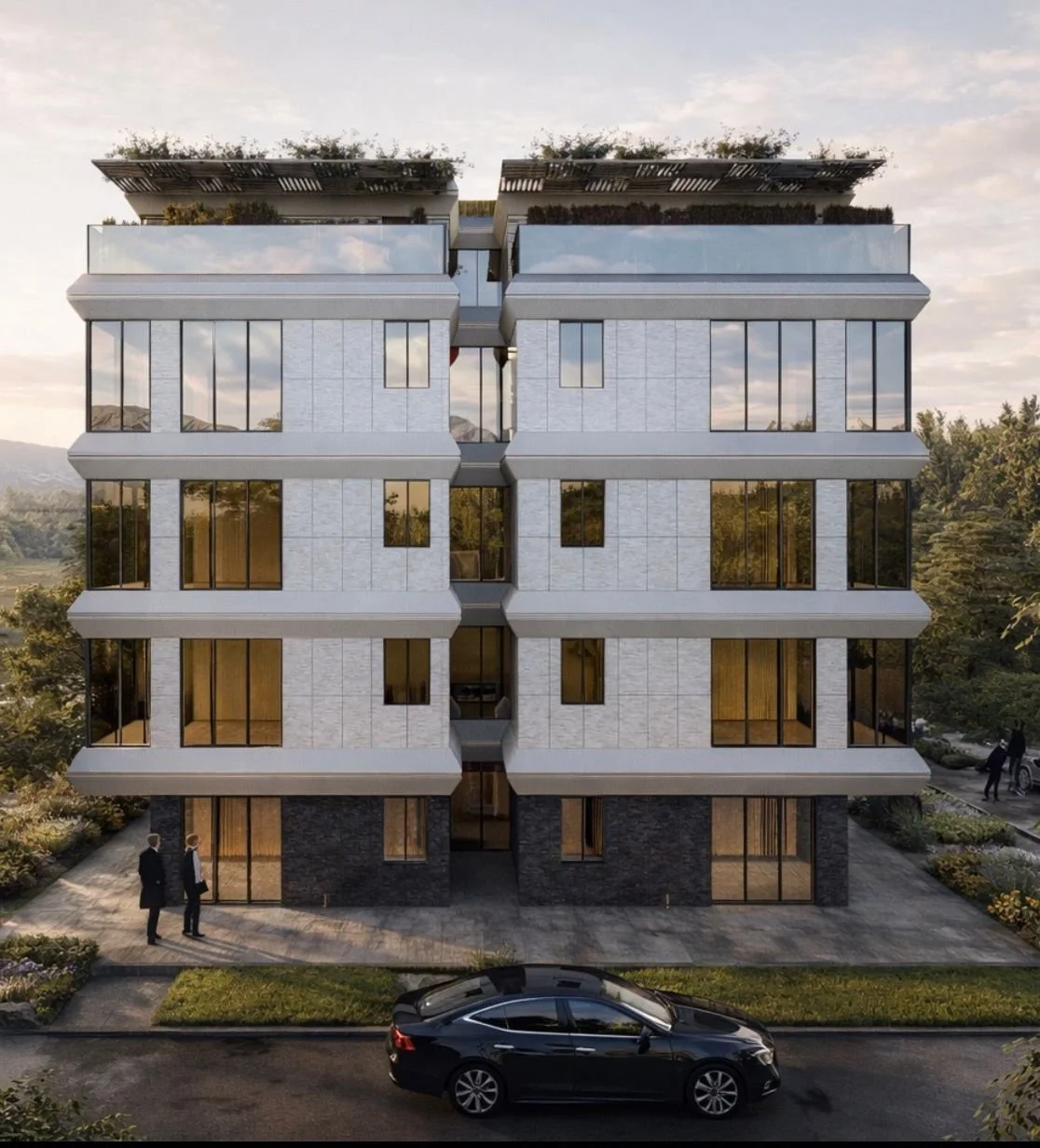 Modern multi-story residential building with large glass windows, set against a scenic outdoor backdrop, with cars parked nearby and people walking on the sidewalk.