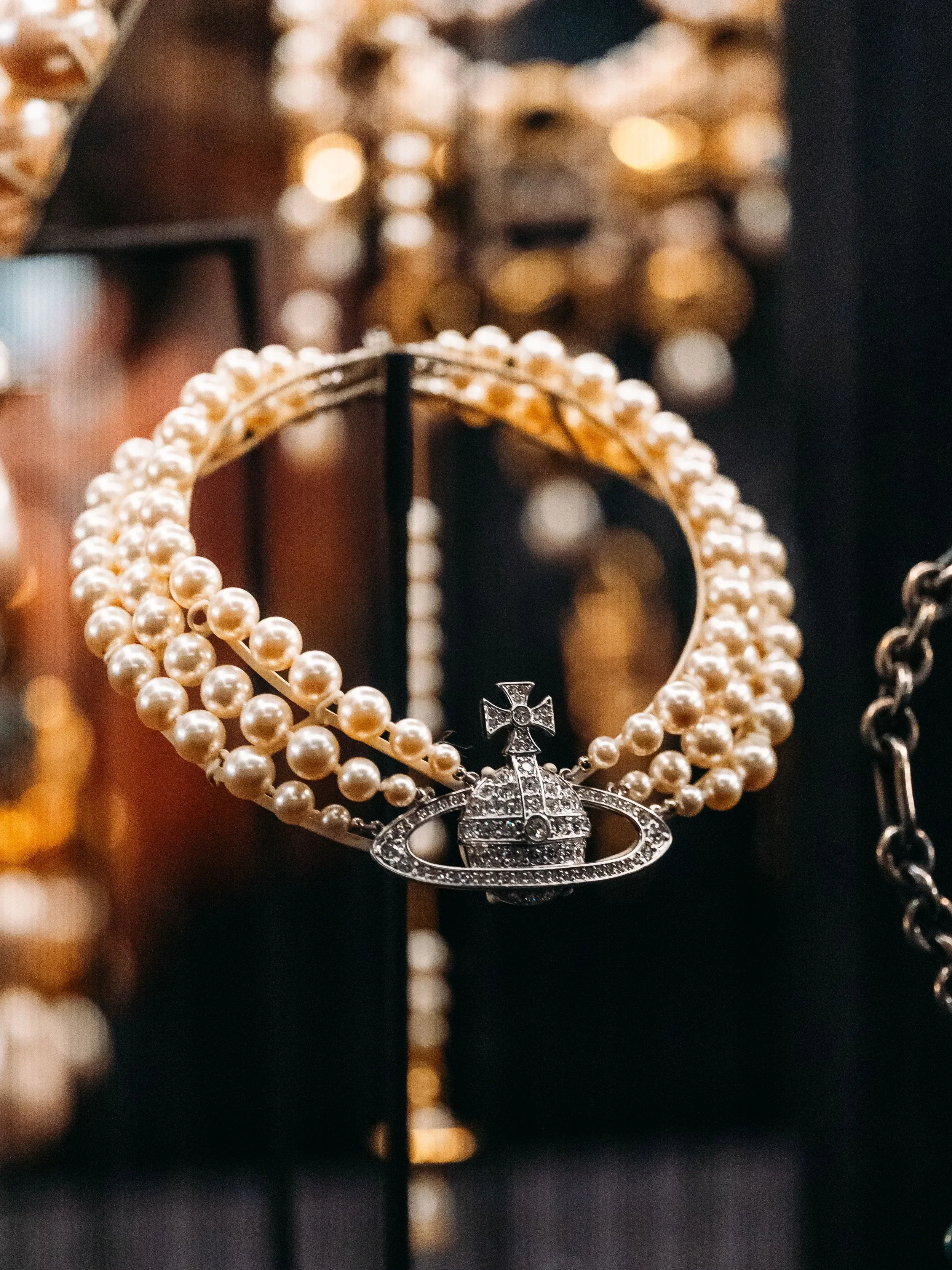 Elegant pearl necklace with a designer-inspired pendant displayed in a curated vintage jewelry collection.