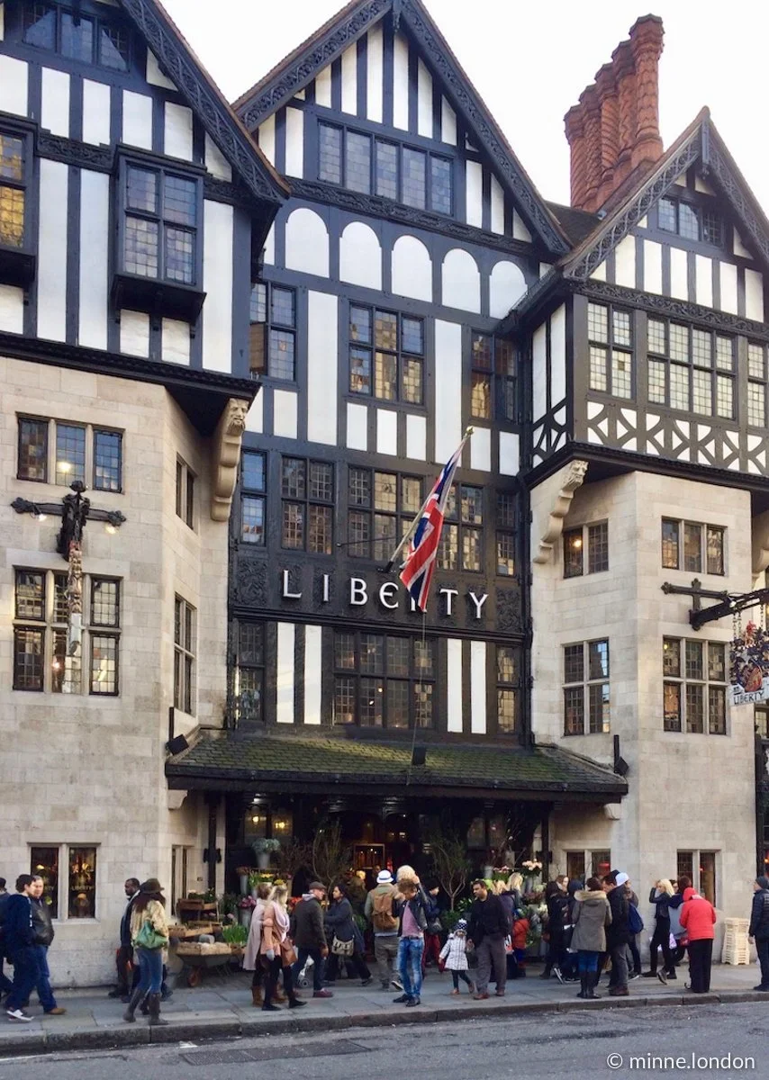 Historic Liberty London department store featuring iconic Tudor-style architecture and the Union Jack flag above the entrance.