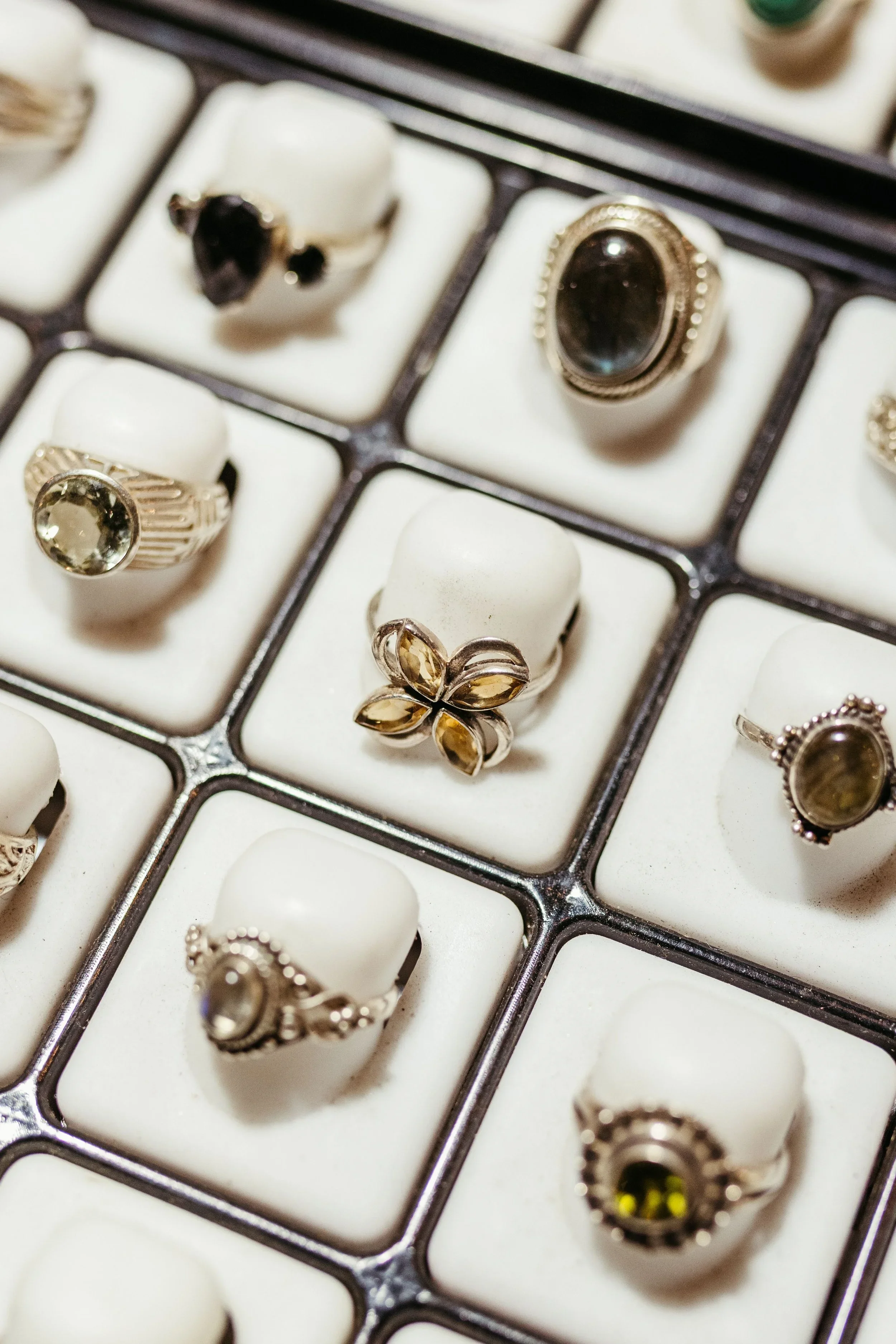 Display of vintage gemstone and silver rings arranged in a jewelry showcase tray for collectors and treasure hunters.