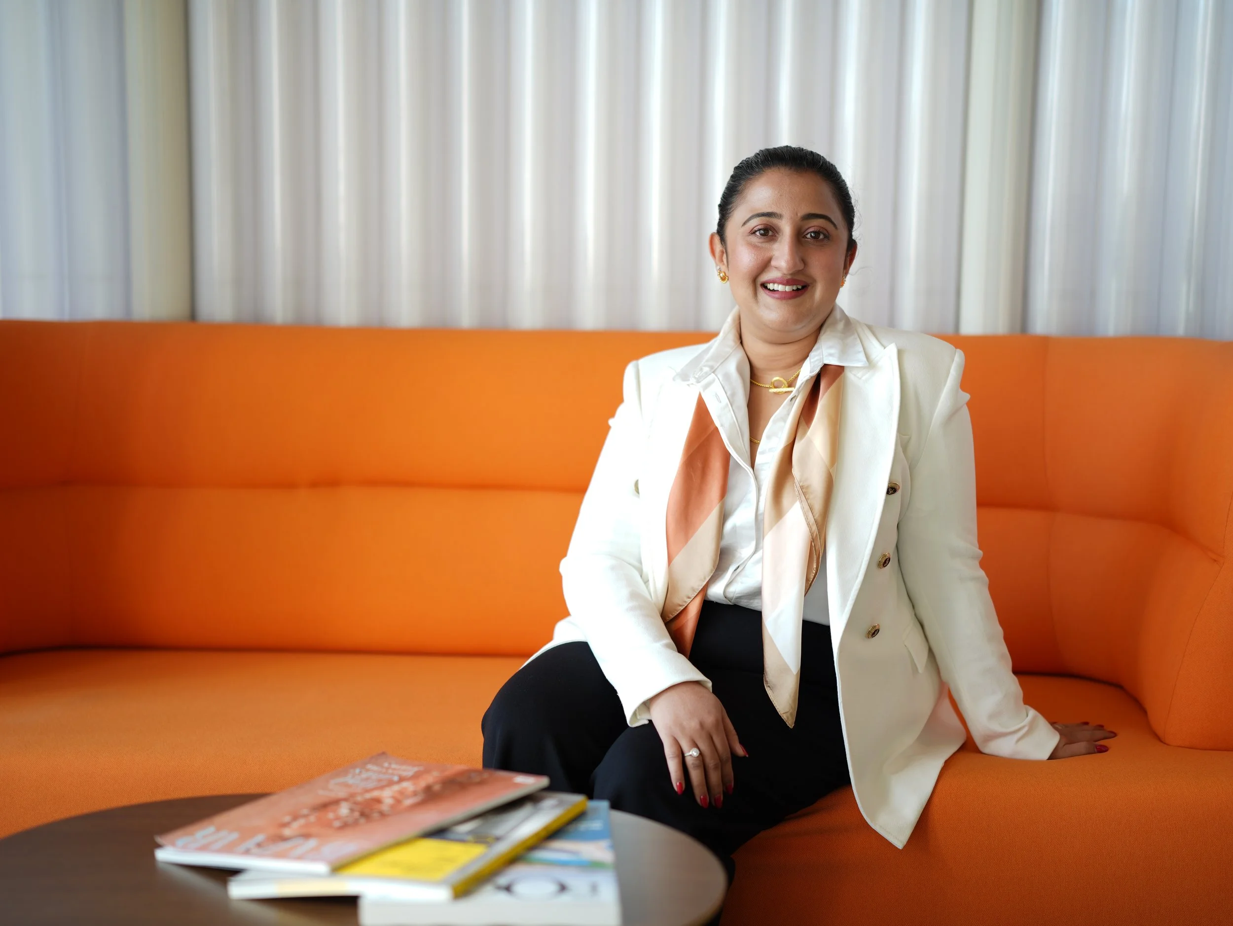 nina mathew seated on a couch