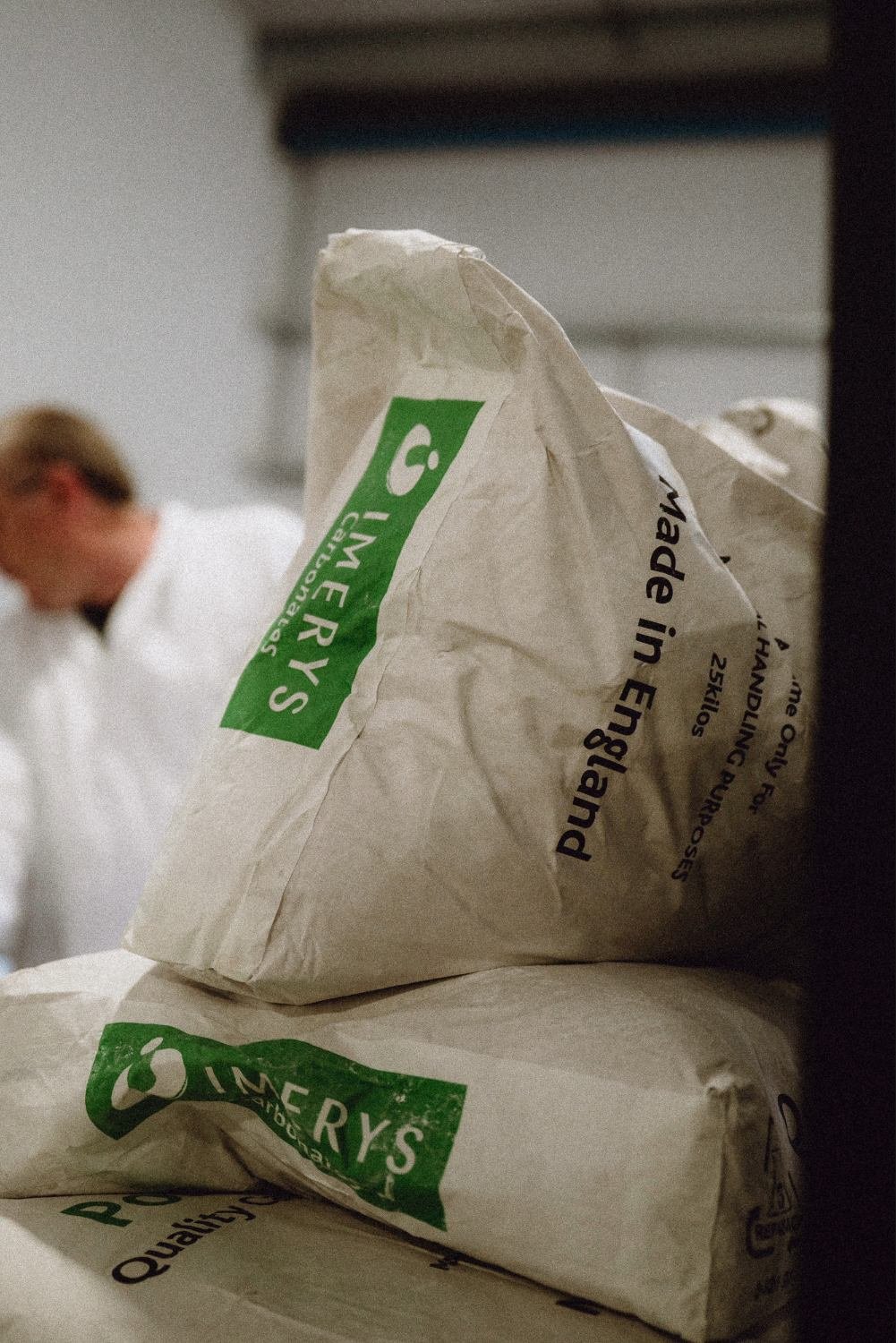 Bags of calcium carbonate stacked up in our factory. This is one of the ingredients used for our bespoke paint manufacturing.