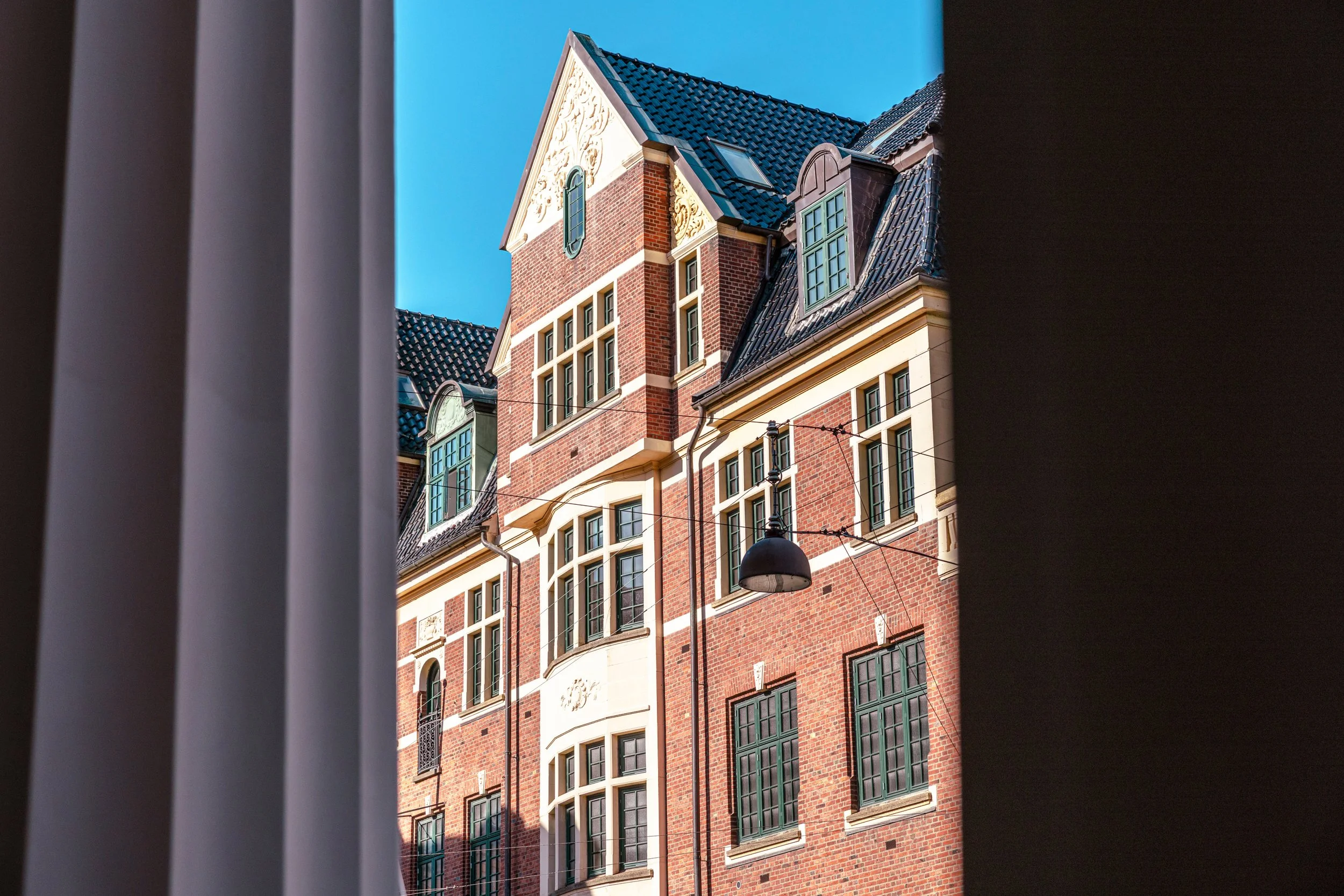 Detalje af Nørregade 7 i København K med historisk rødstensfacade, markante gavle, originale vinduespartier og håndværksmæssige detaljer.