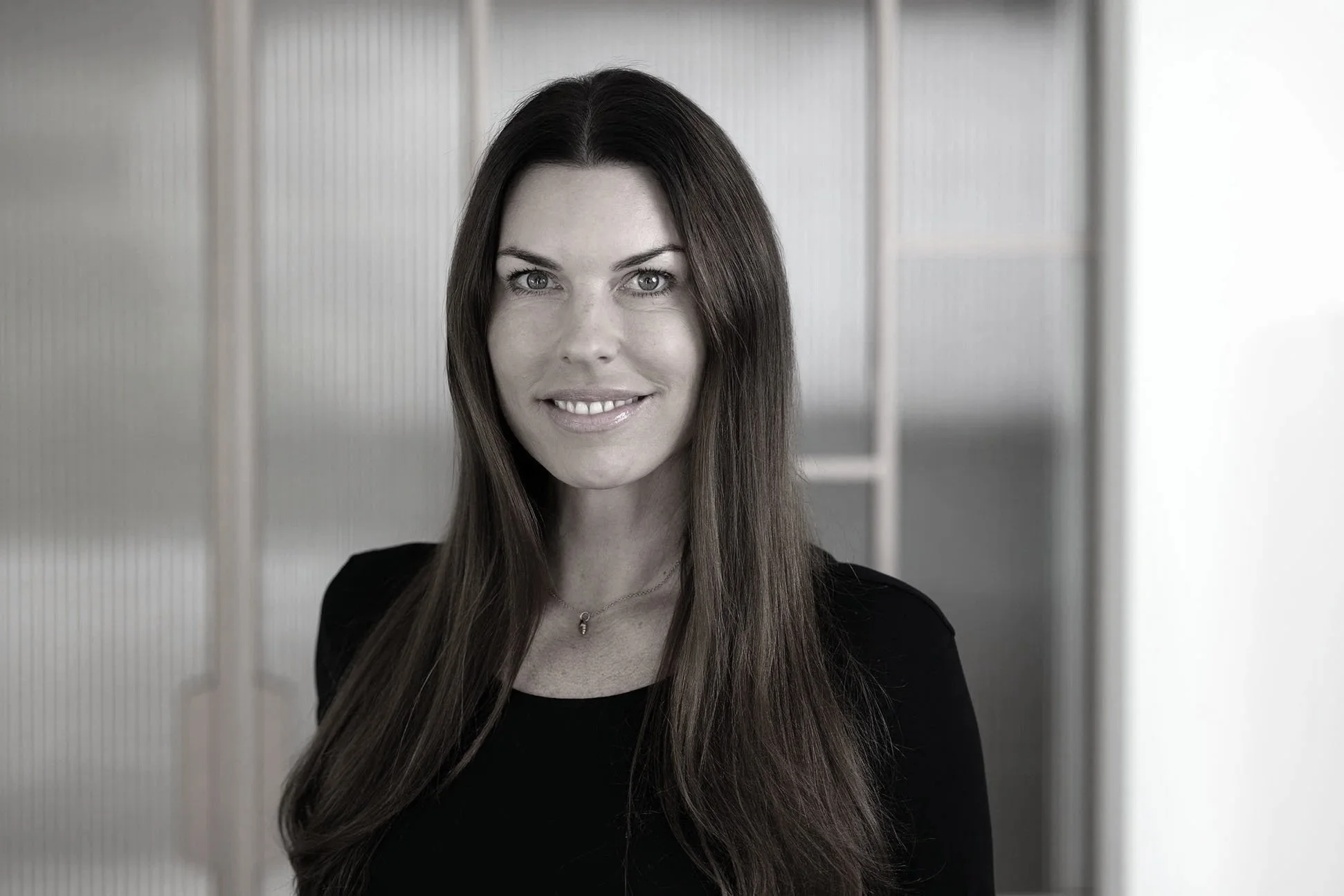 Sarah Johannsen Roth vor einem gläsernen Hintergrund.
