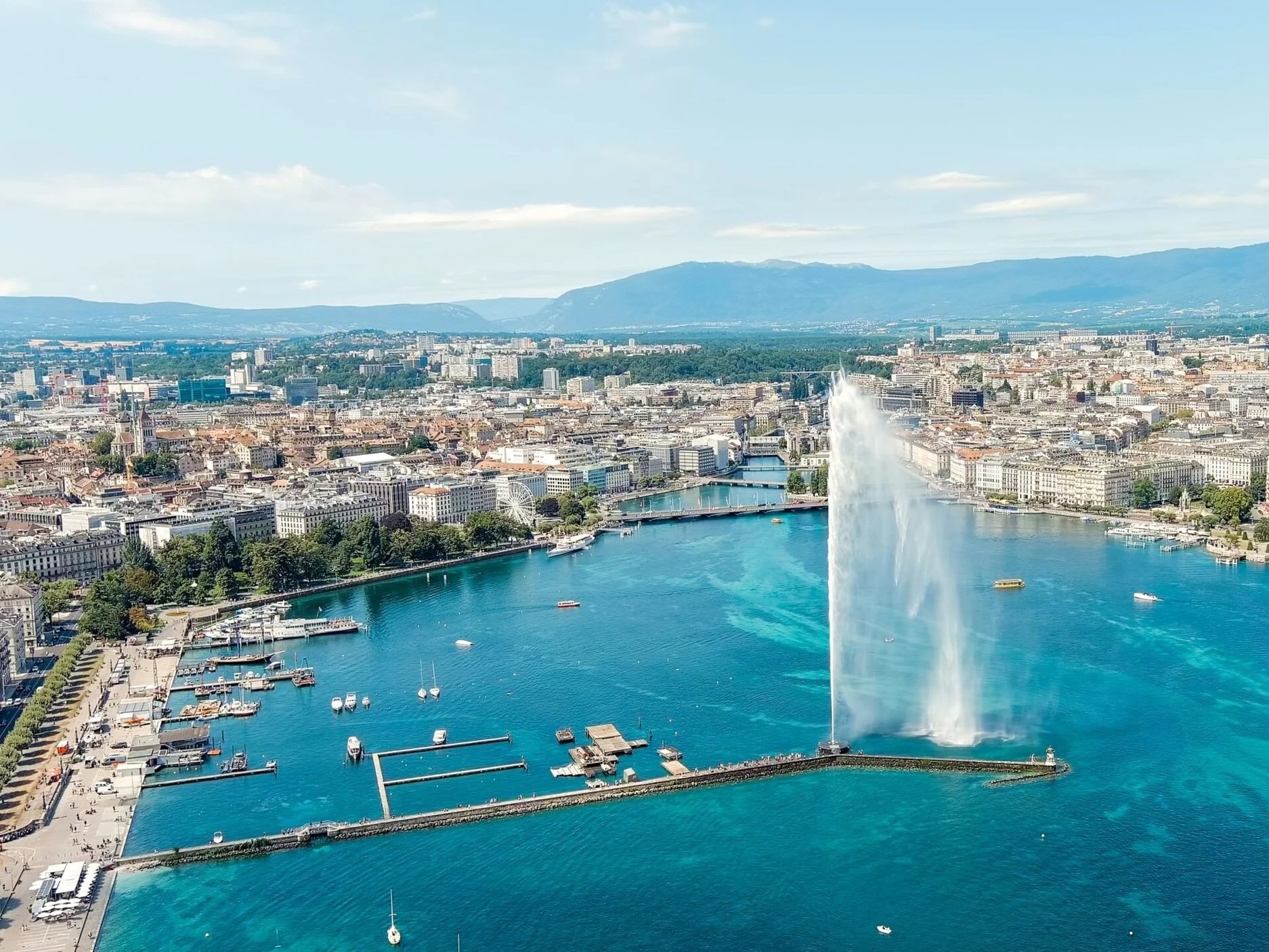 RS56804_Geneva-Switzerland.-Fountain-Je-Deau.-Large-fountain-jet-up-to-140-meters.-The-main-attraction-of-Lake-Geneva.-Summer-day-Aerial-View-scaled.jpg