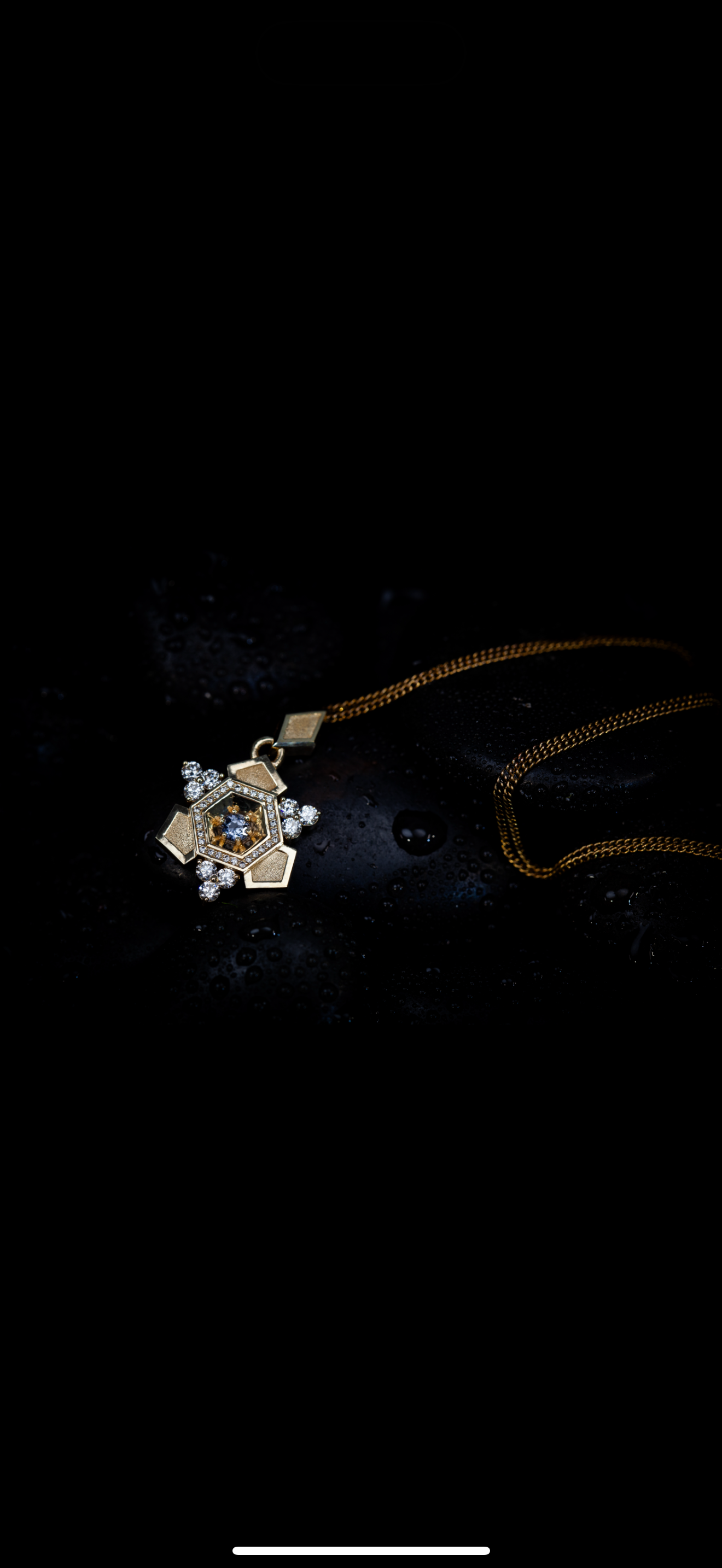 A gold necklace with a detailed, ornate pendant decorated with diamonds and a central gemstone, resting on a wet, black surface.