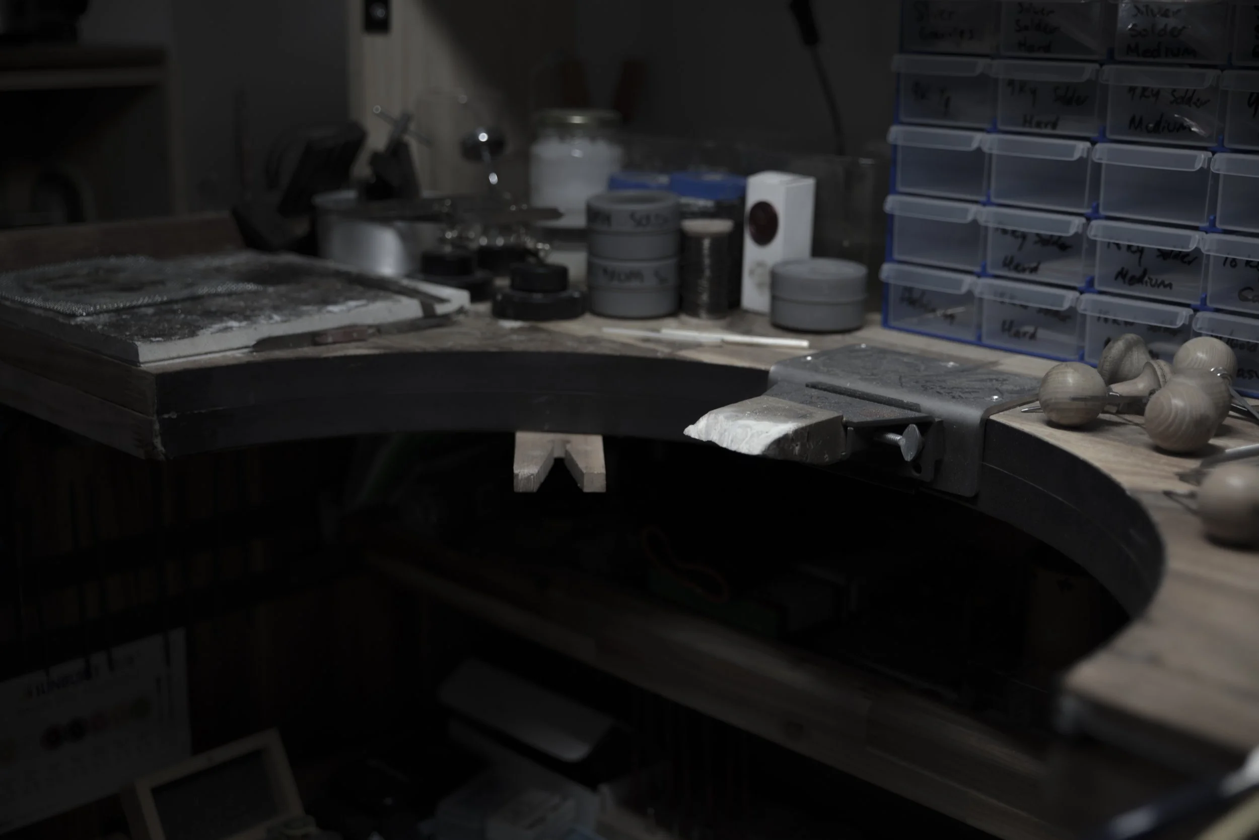 Workbenches and storage drawers in a workshop, filled with tools and supplies.