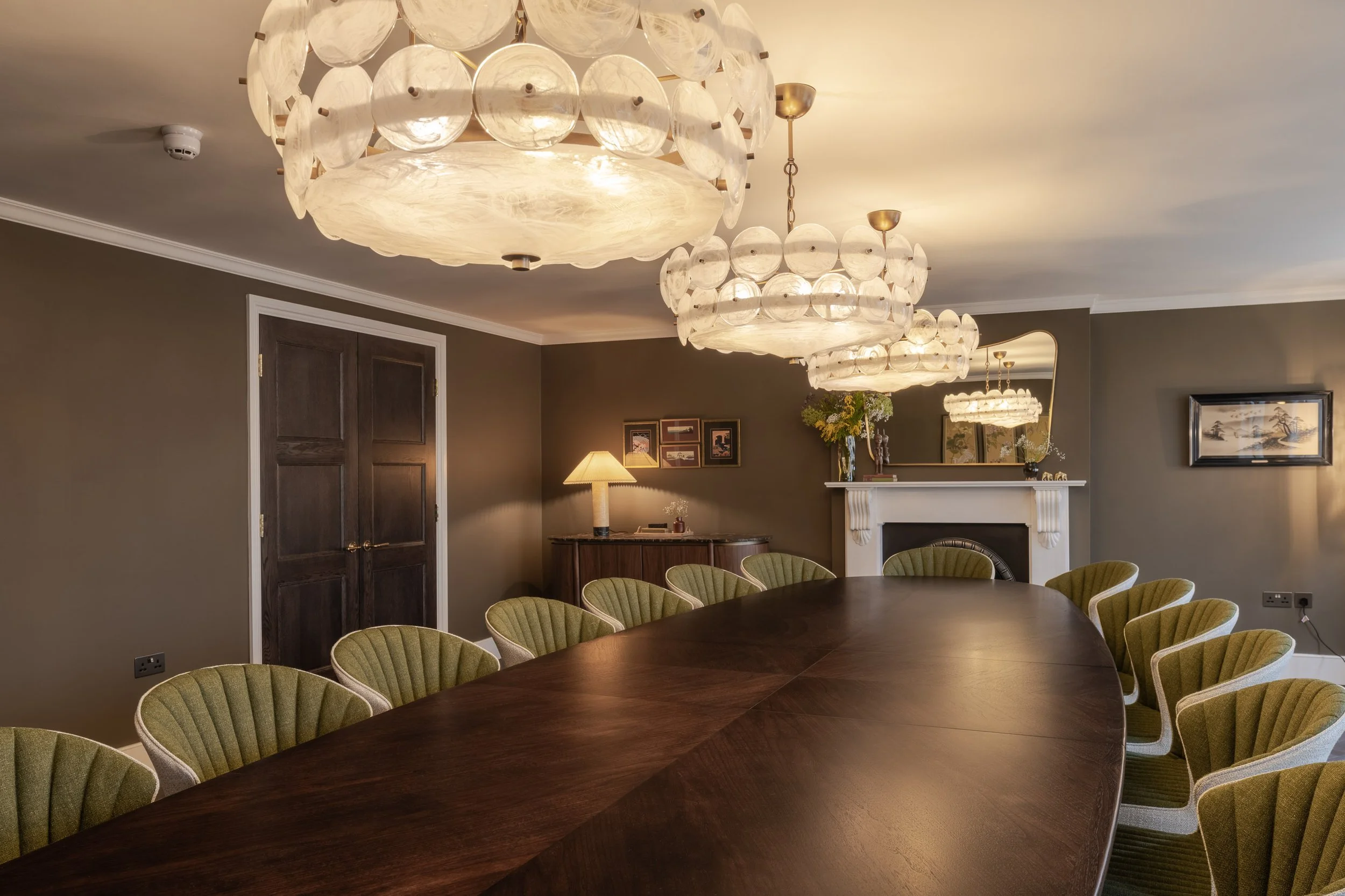 A private dining room with contemporary chandeliers, bespoke joinery, solid walnut dining table. Central London Restaurant Interior Design.