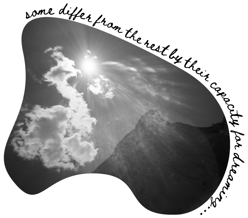 Black and white photo of a mountain landscape with a partly cloudy sky, sun shining through clouds, and sunlight rays visible.
