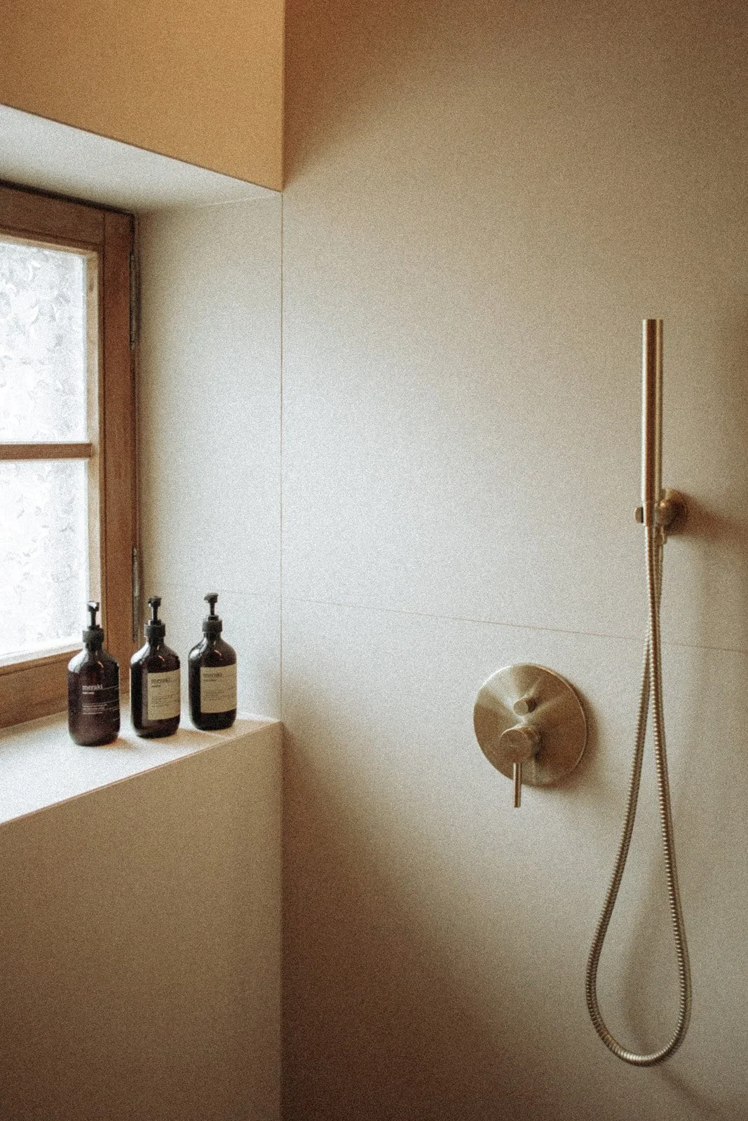 Prysznic w łazience Ananda Retreat House z minimalistycznym wyposażeniem i oknem zapewniającym naturalne światło.