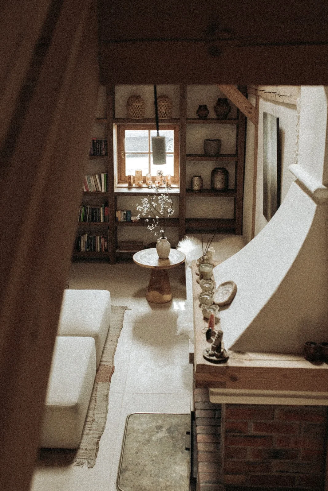 Jasny salon w Ananda Retreat House z wygodną sofą, drewnianym stolikiem i naturalnymi dekoracjami.