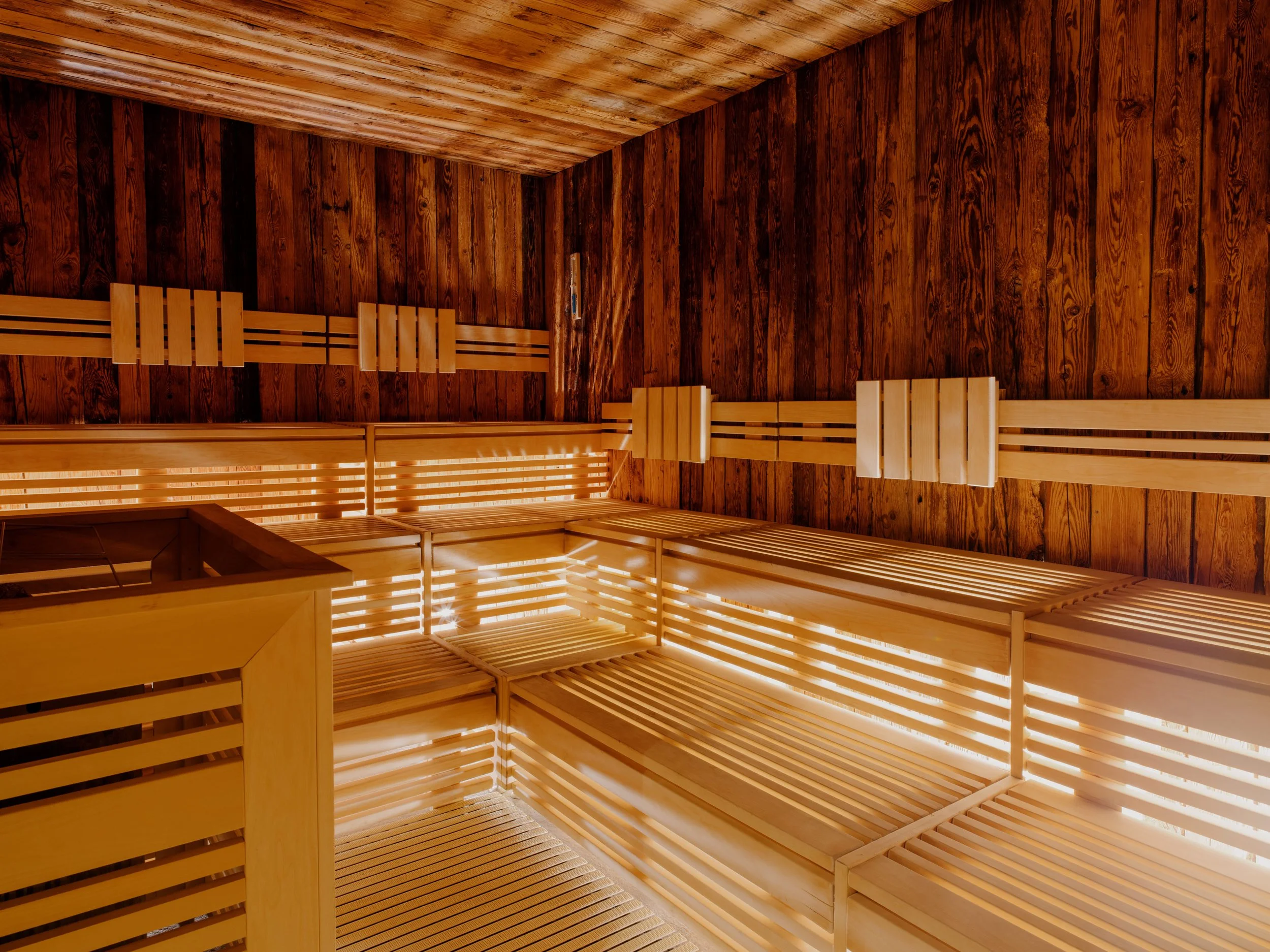 Interior of a sauna with wooden benches and wooden walls and ceiling.